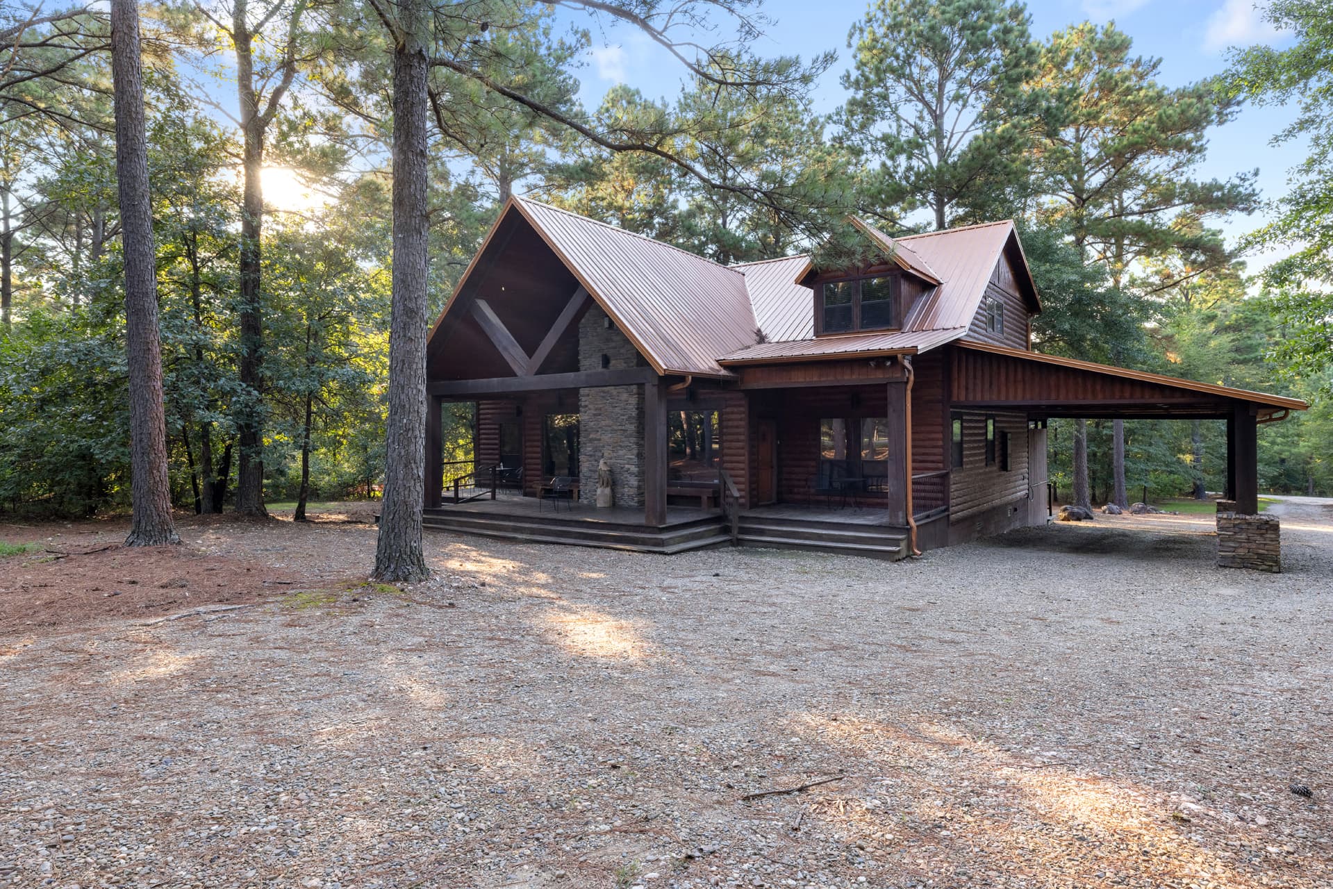 Front of log 2 story cabin with large driveway space