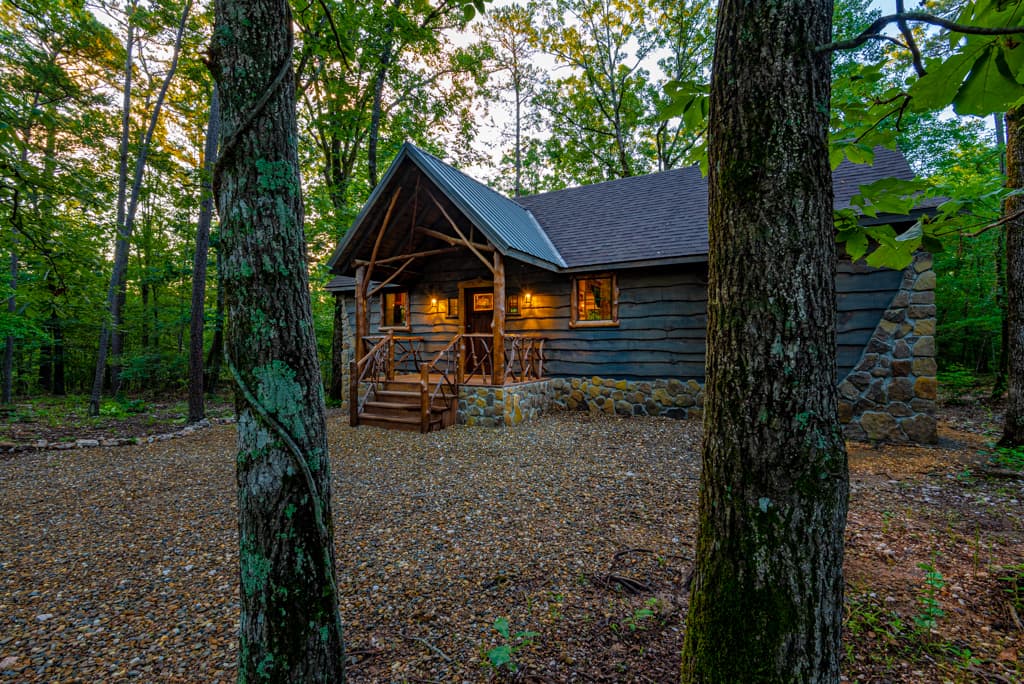 front of log cabin with gravel driveway