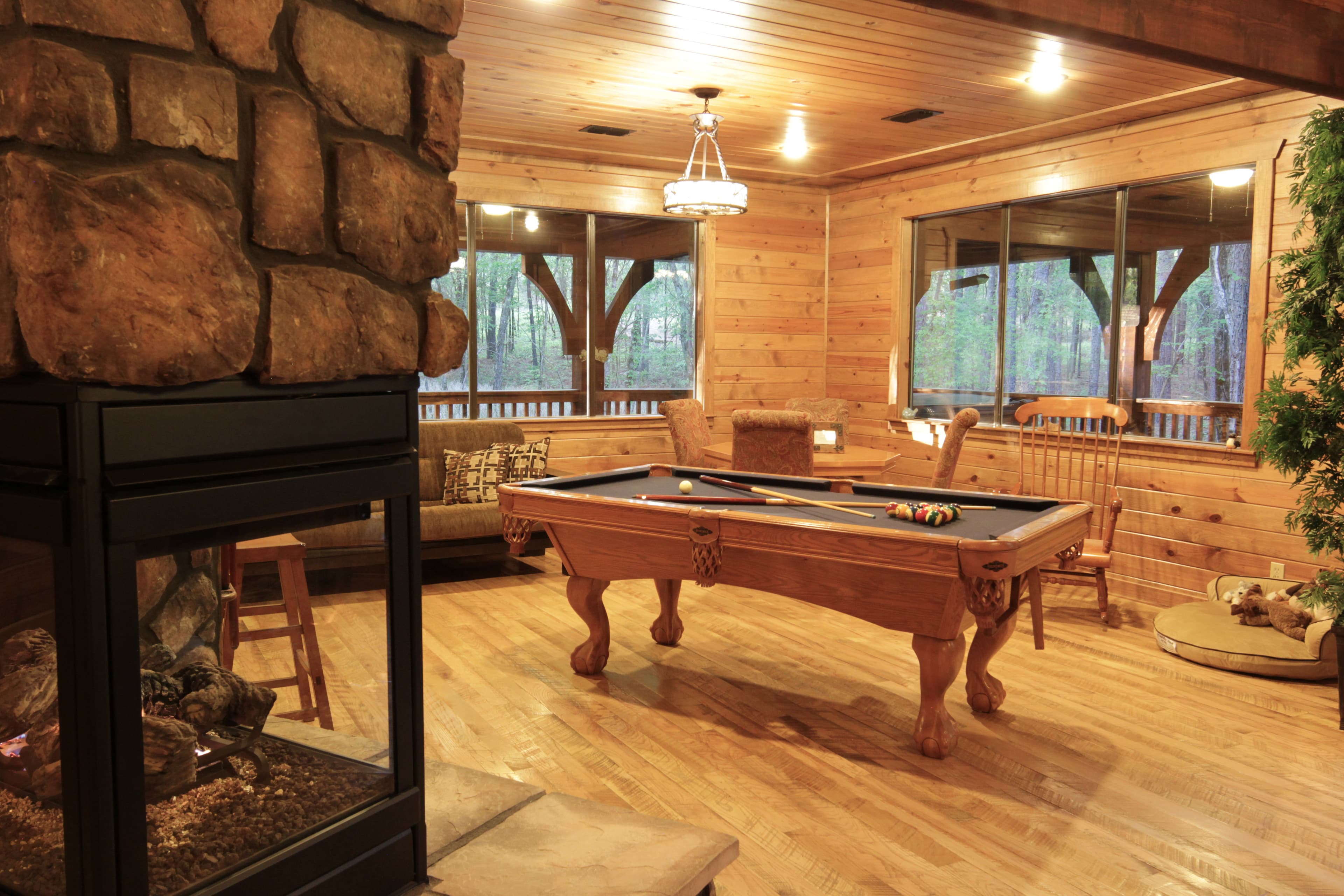 Pool table in open game room by fireplace