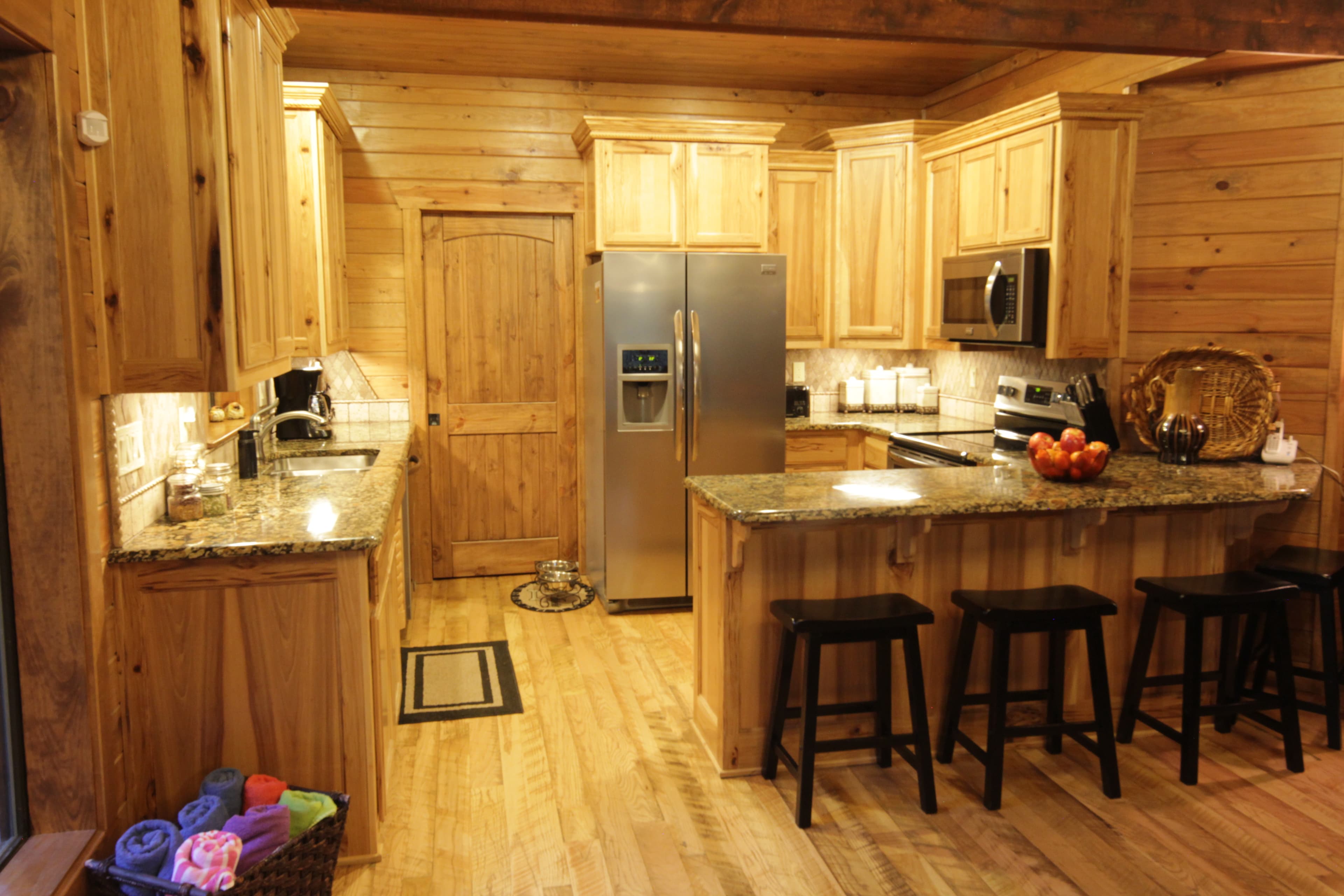 Open full kitchen with 3 stools on bar, hot tub towels