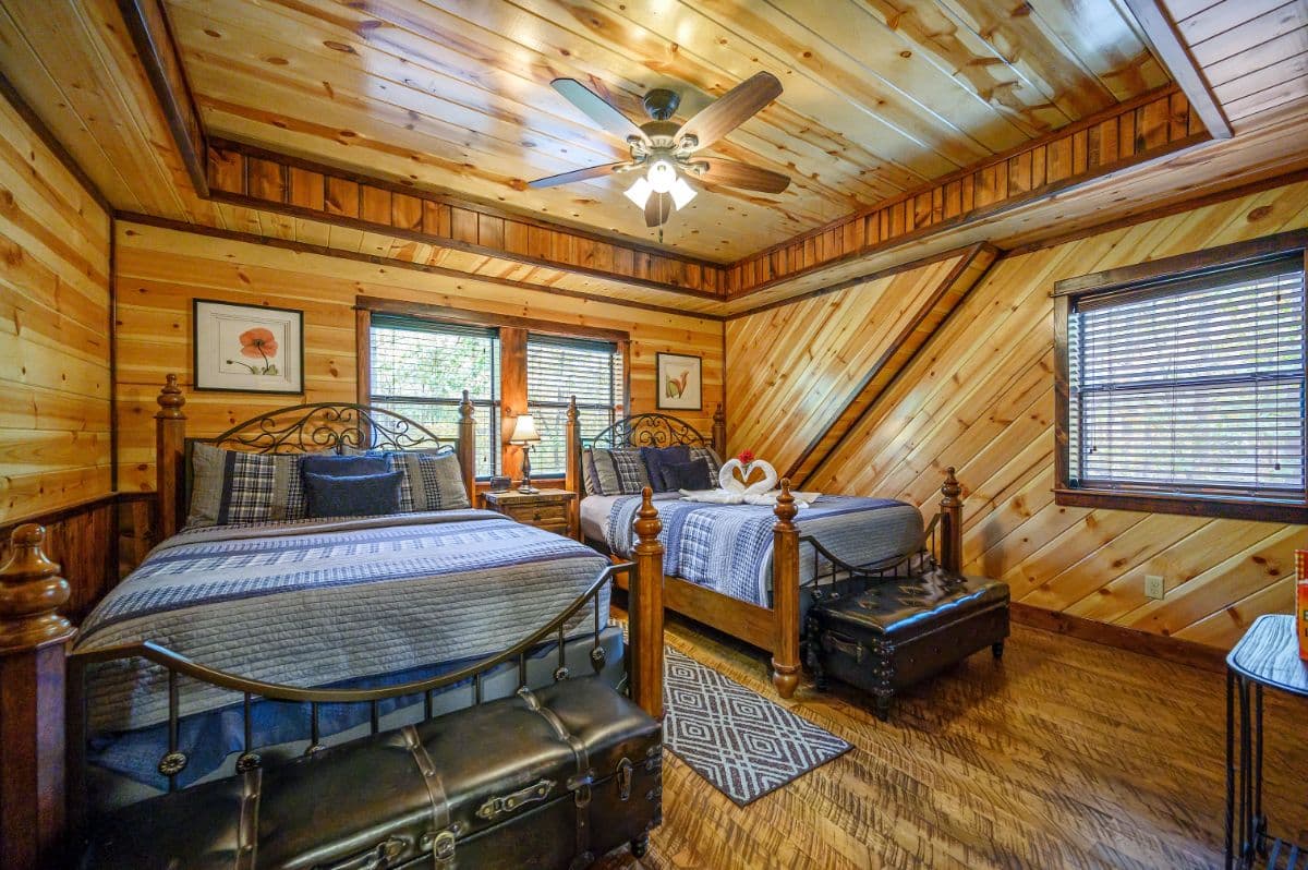 Upstairs queen beds with benches in front, side table, lamp