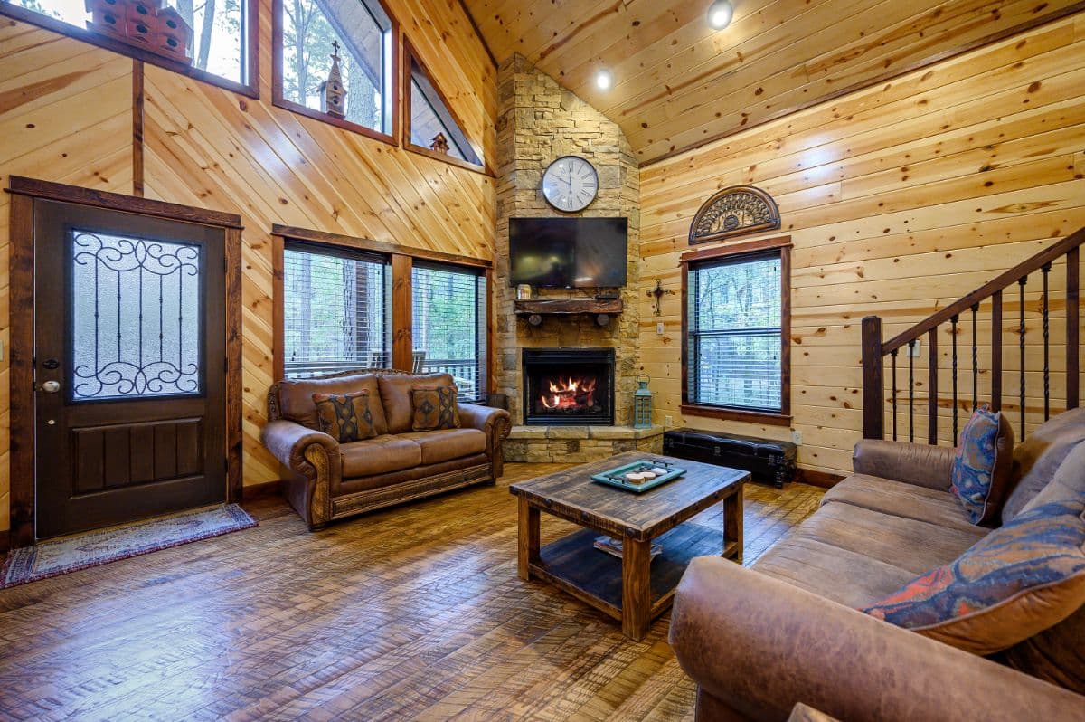 Open living area, couches, coffee table, and fireplace