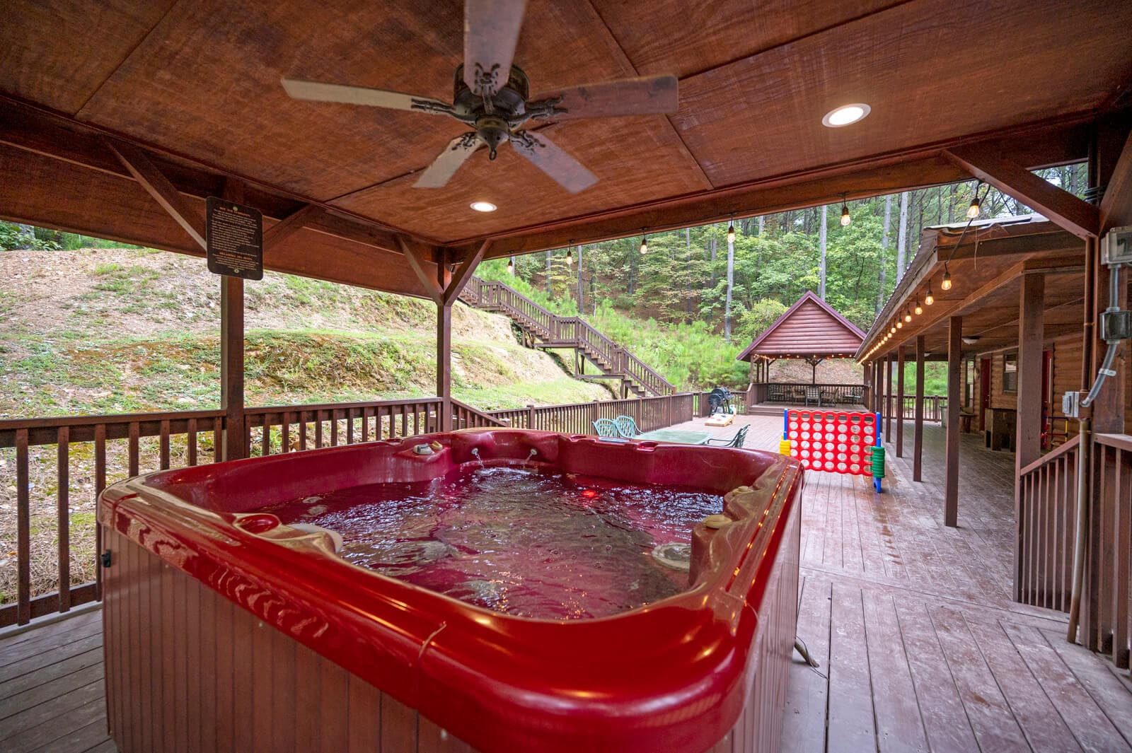 Hot tub under covered porch with forest view