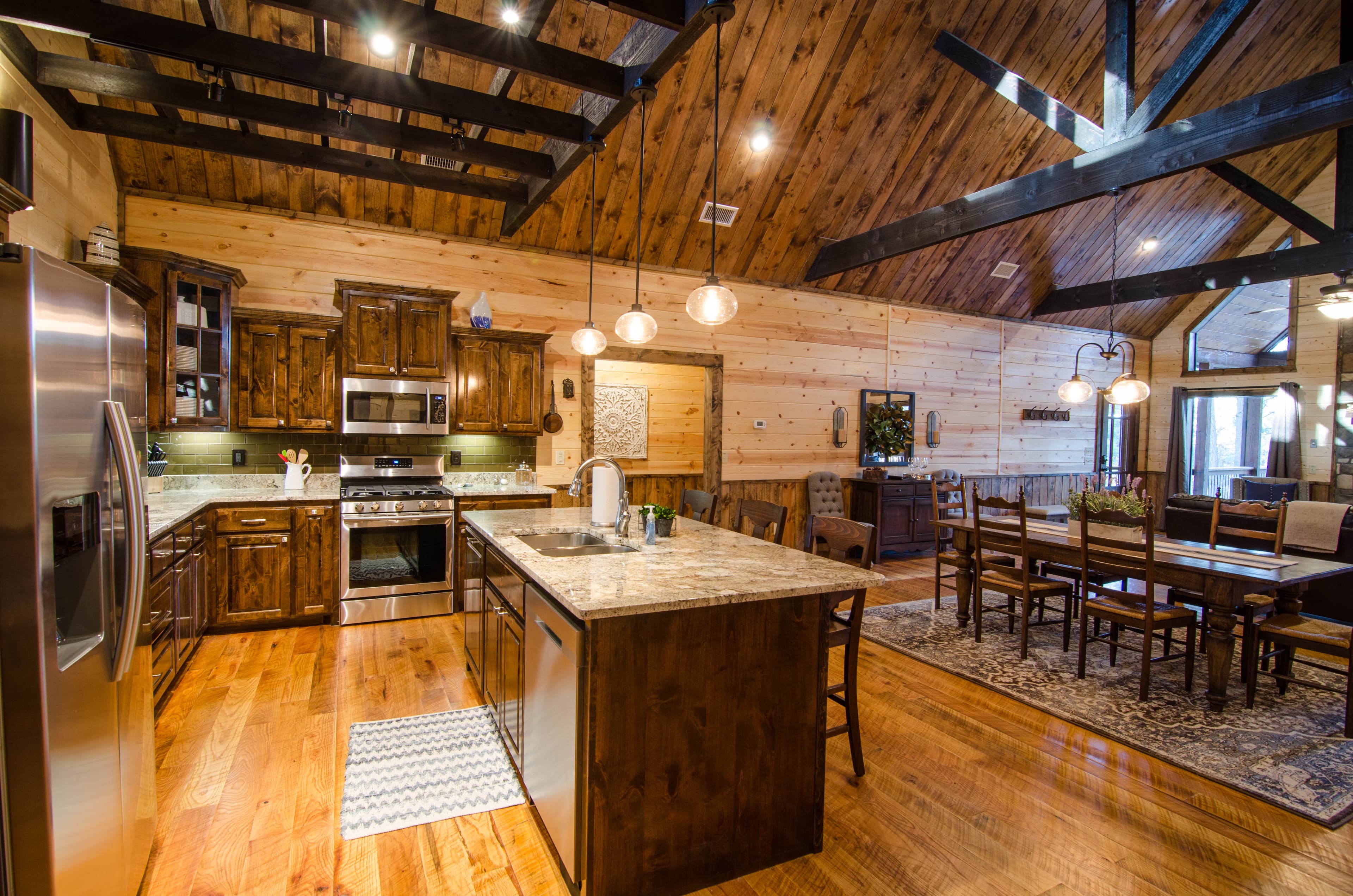 open full kitchen with dark wood beam accents hanging from ceiling