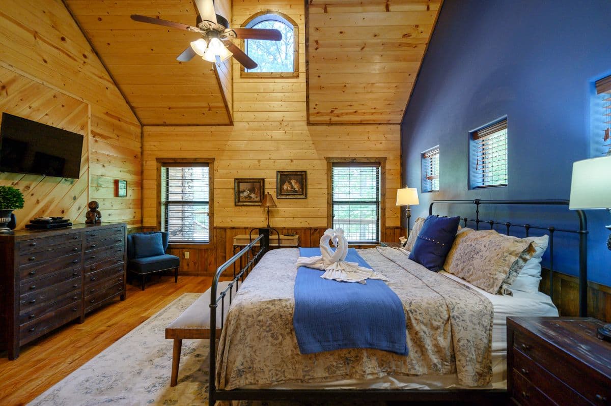 king bedroom with tv, dresser, side tables, and lamps