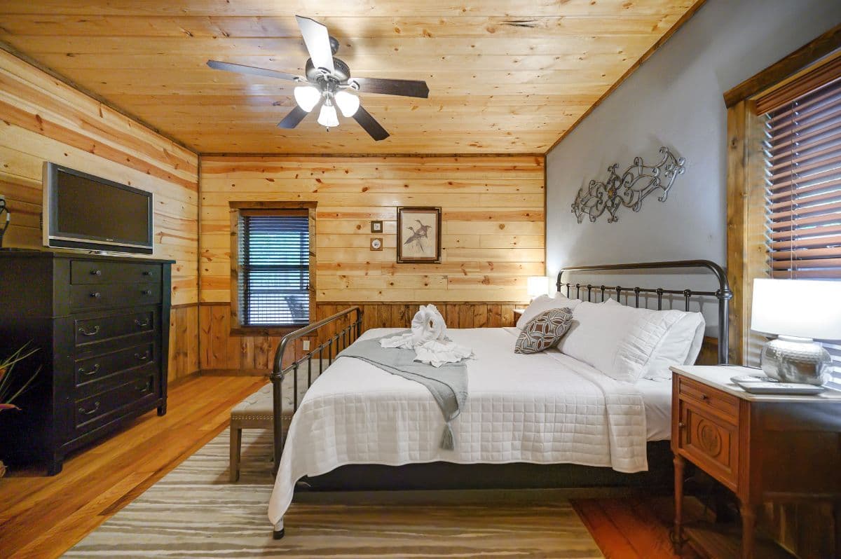 king bedroom with tv, dresser, side tables, and lamps