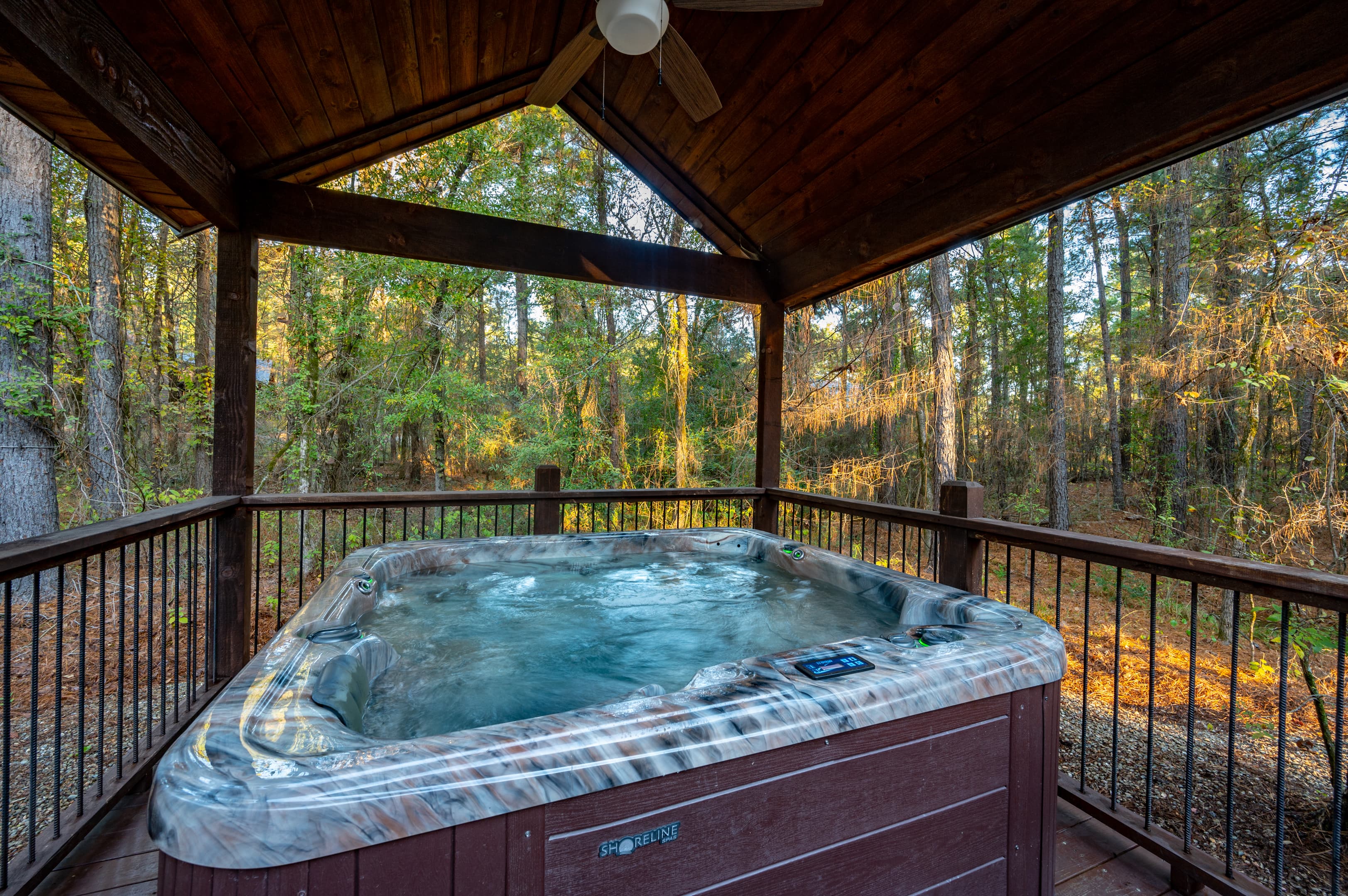 Hot tub on covered patio with forest view