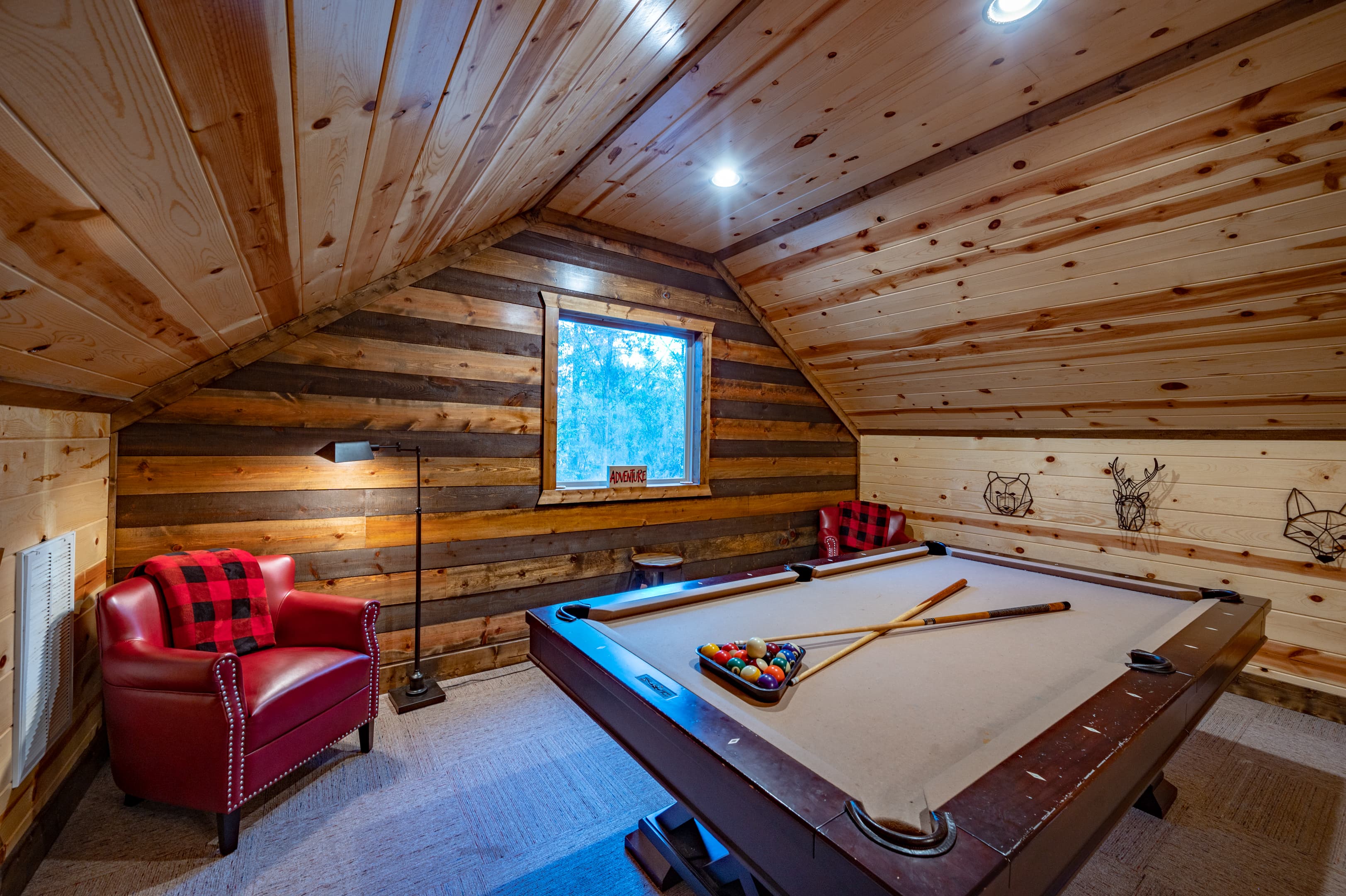 Upstairs pool table, red leather chair, lamp, window