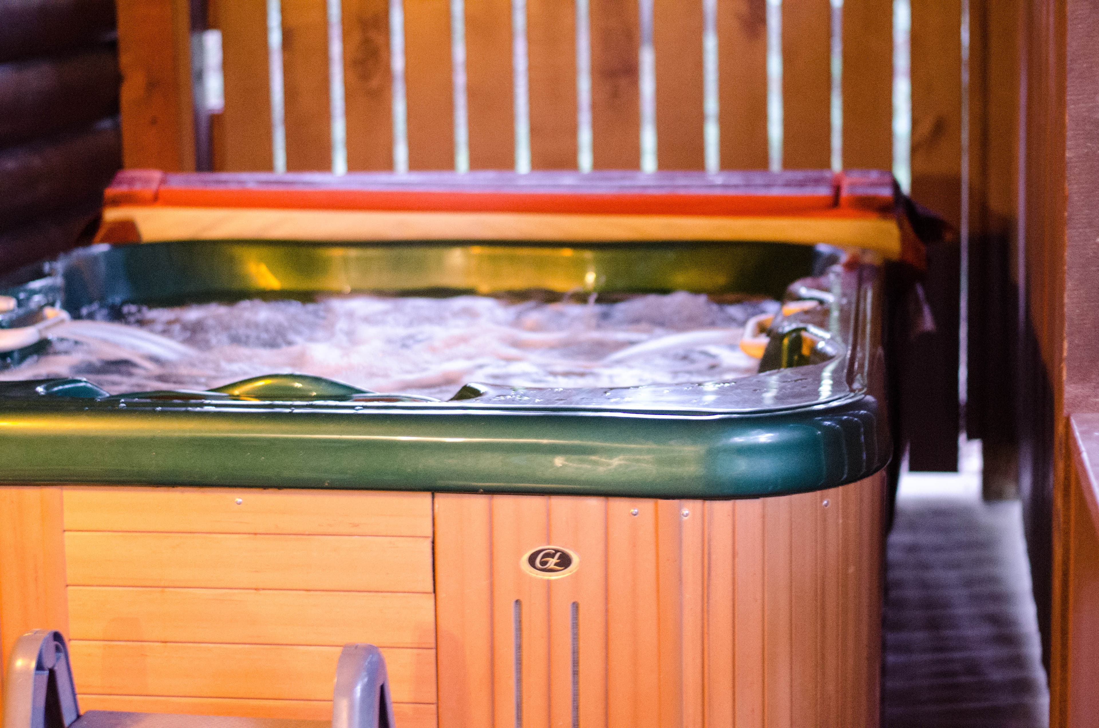 Hot tub with steps under covered wooden porch