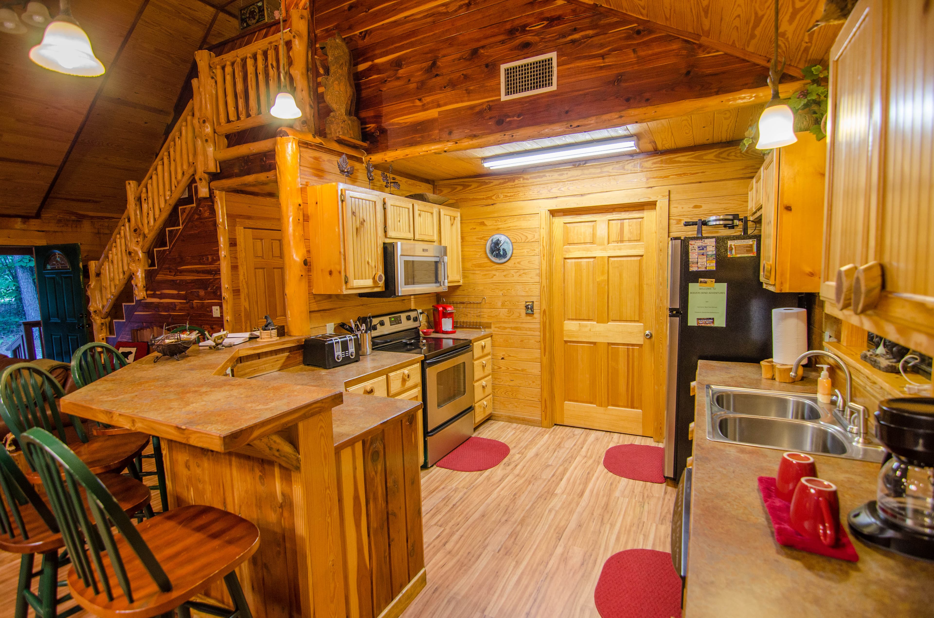 Kitchen with red rugs and regular coffee maker, bar seating