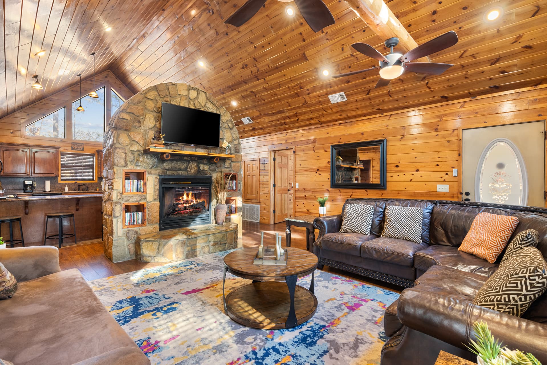 Living area with couches, side tables, and lamps, large abstract rug