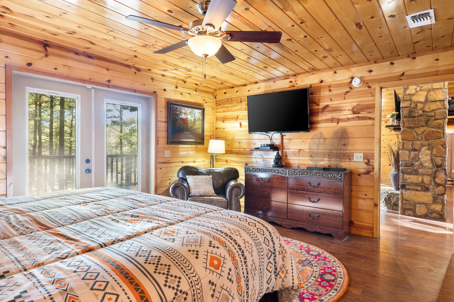 King front bedroom with dresser, TV, and chair