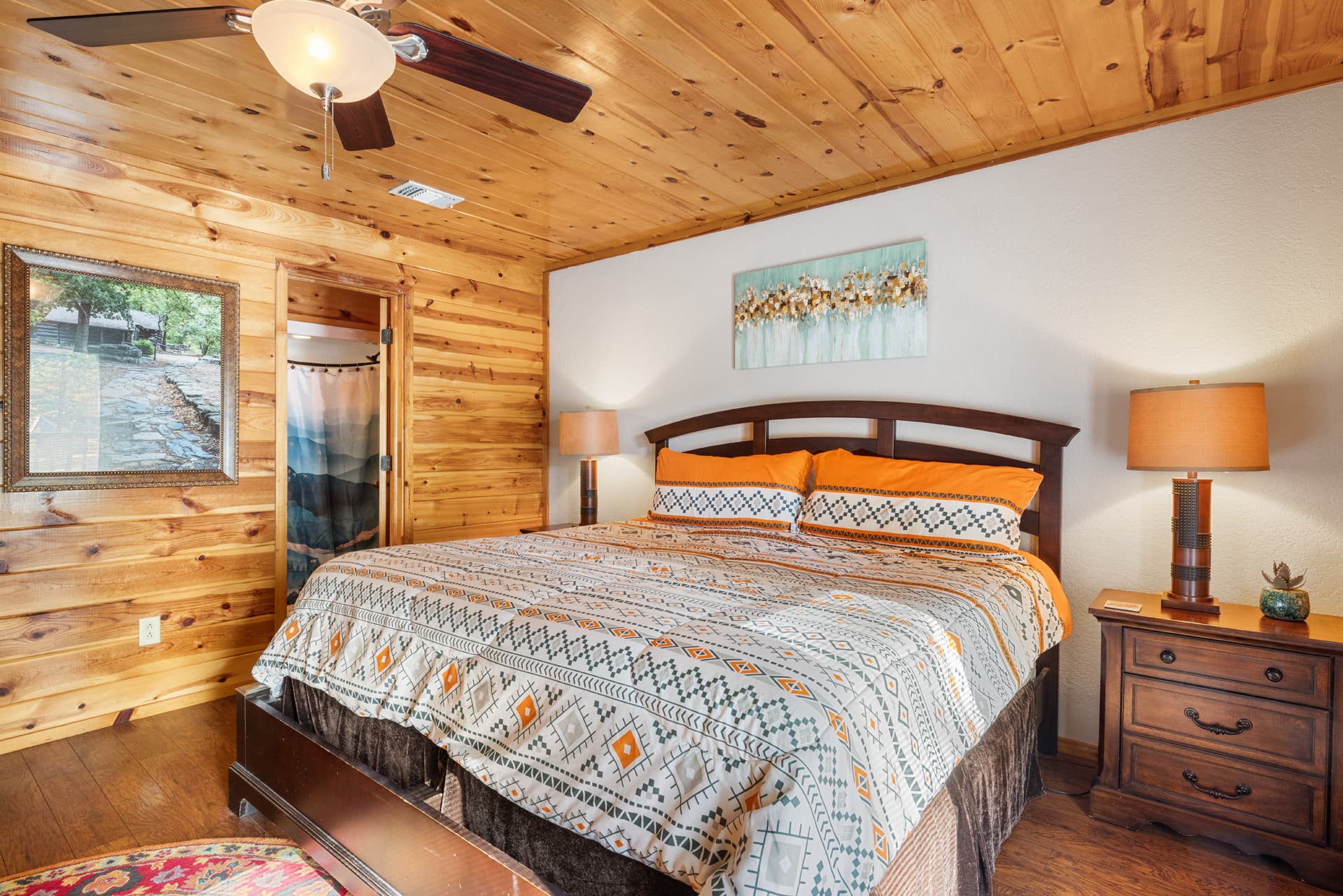 King bedroom with side tables, lamps, attached full bathroom