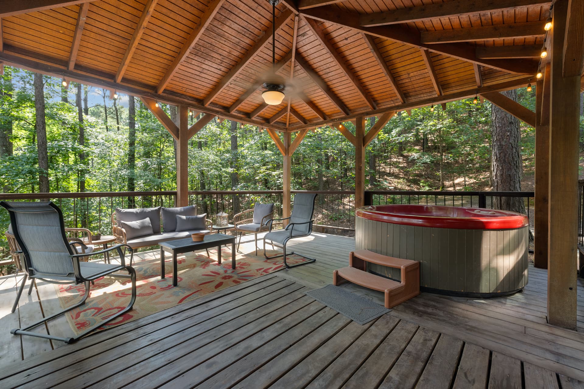 Hot tub on side deck with patio seating near the grill