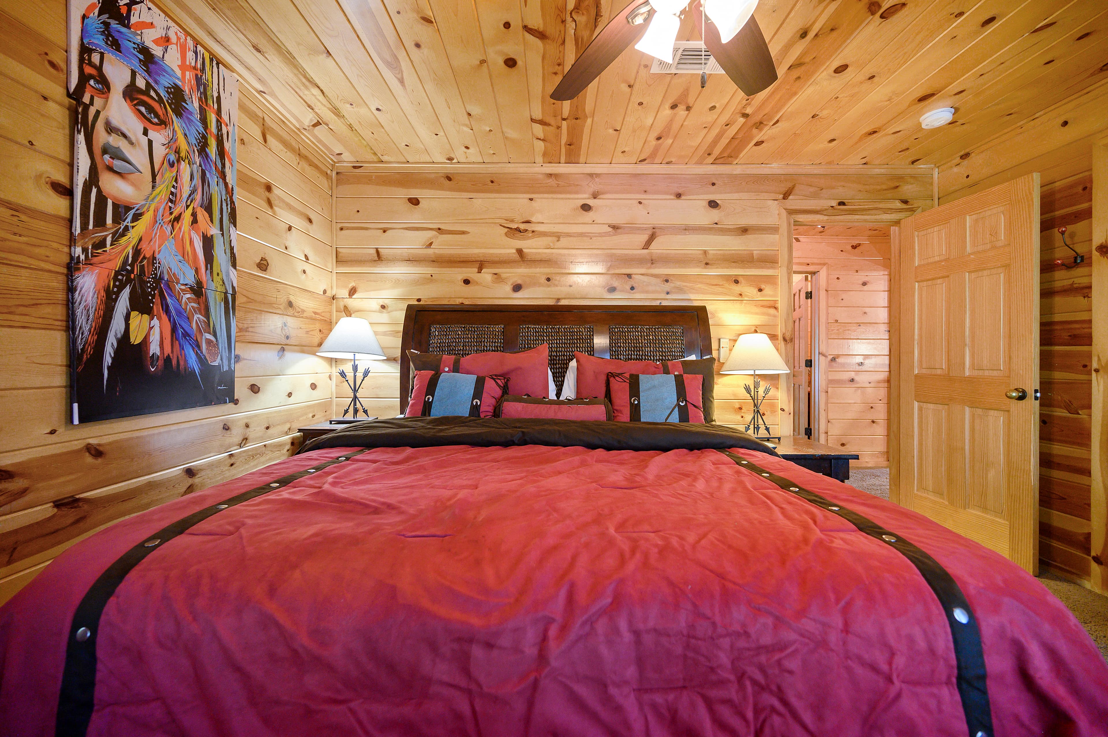 Upstairs king bedroom with side tables and TV, and a table with 2 drawers