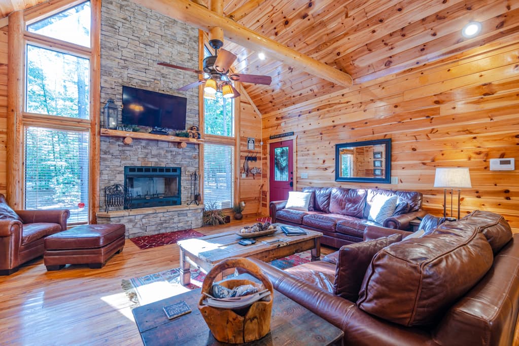 Living area with leather couches, TV, and fireplace