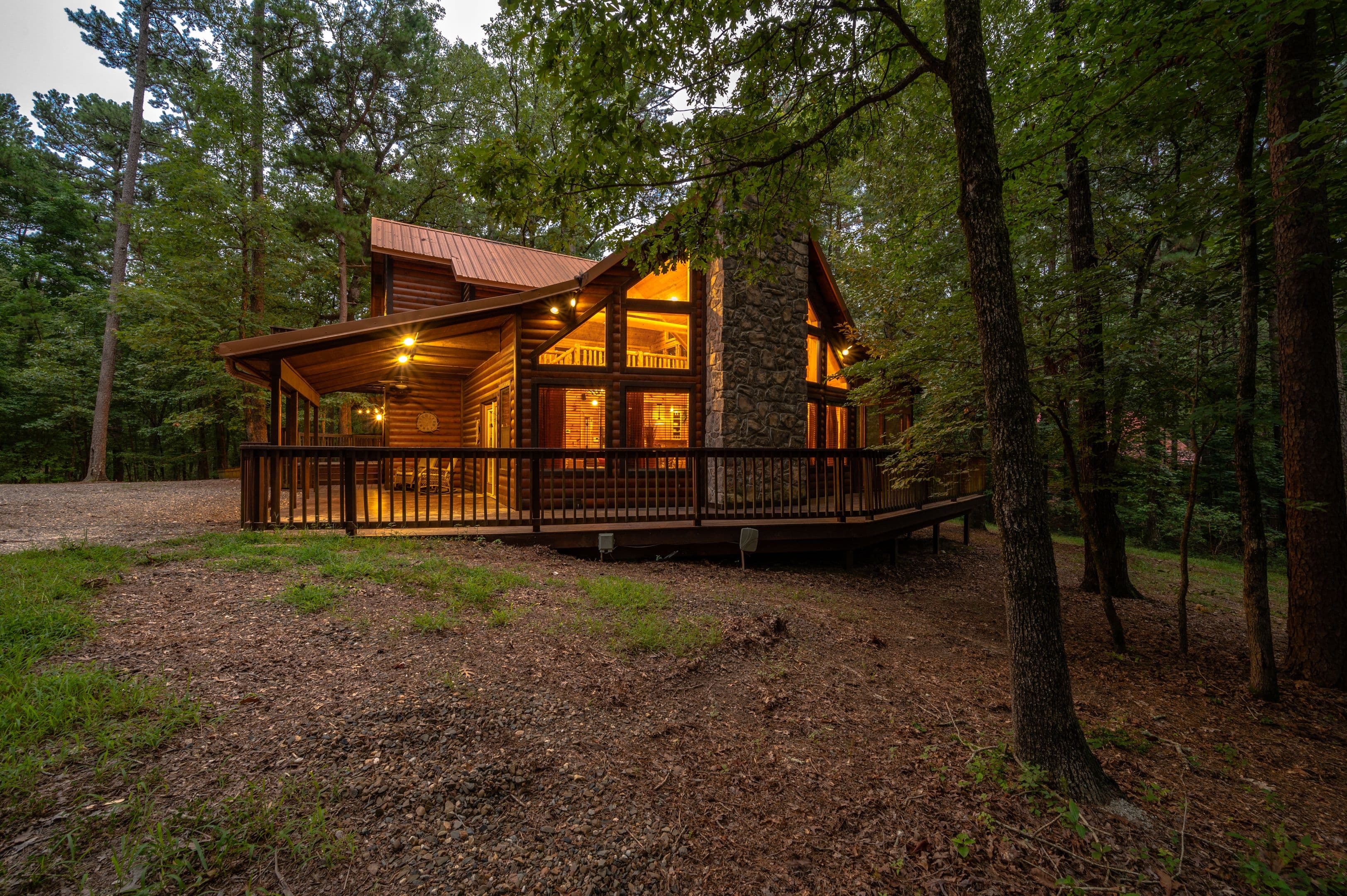 Front of log 2 story cabin with rock fireplace and large circle driveway