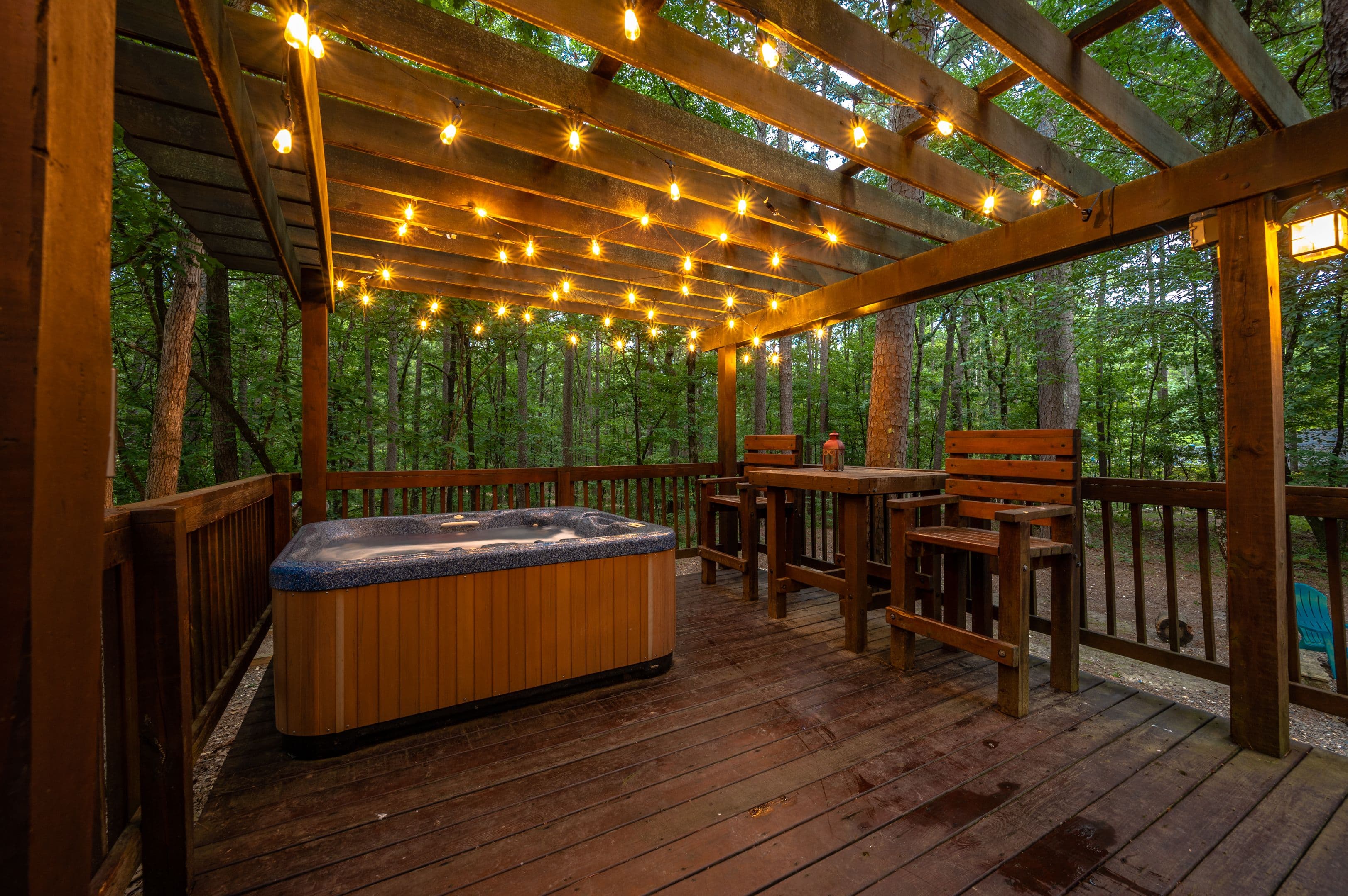 Hot tub on porch with string lights above