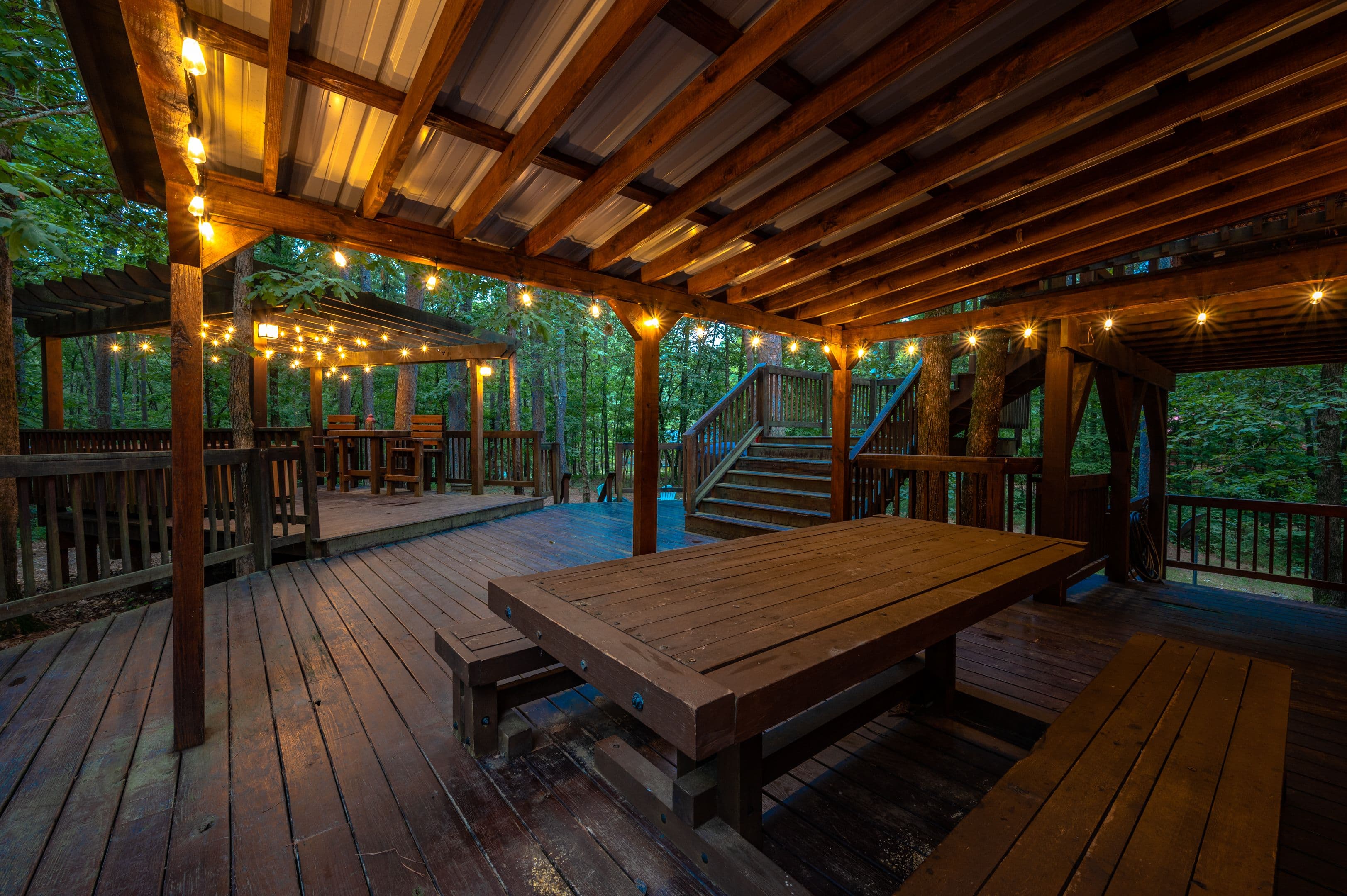Outdoor table on covered porch with lights around porch roof