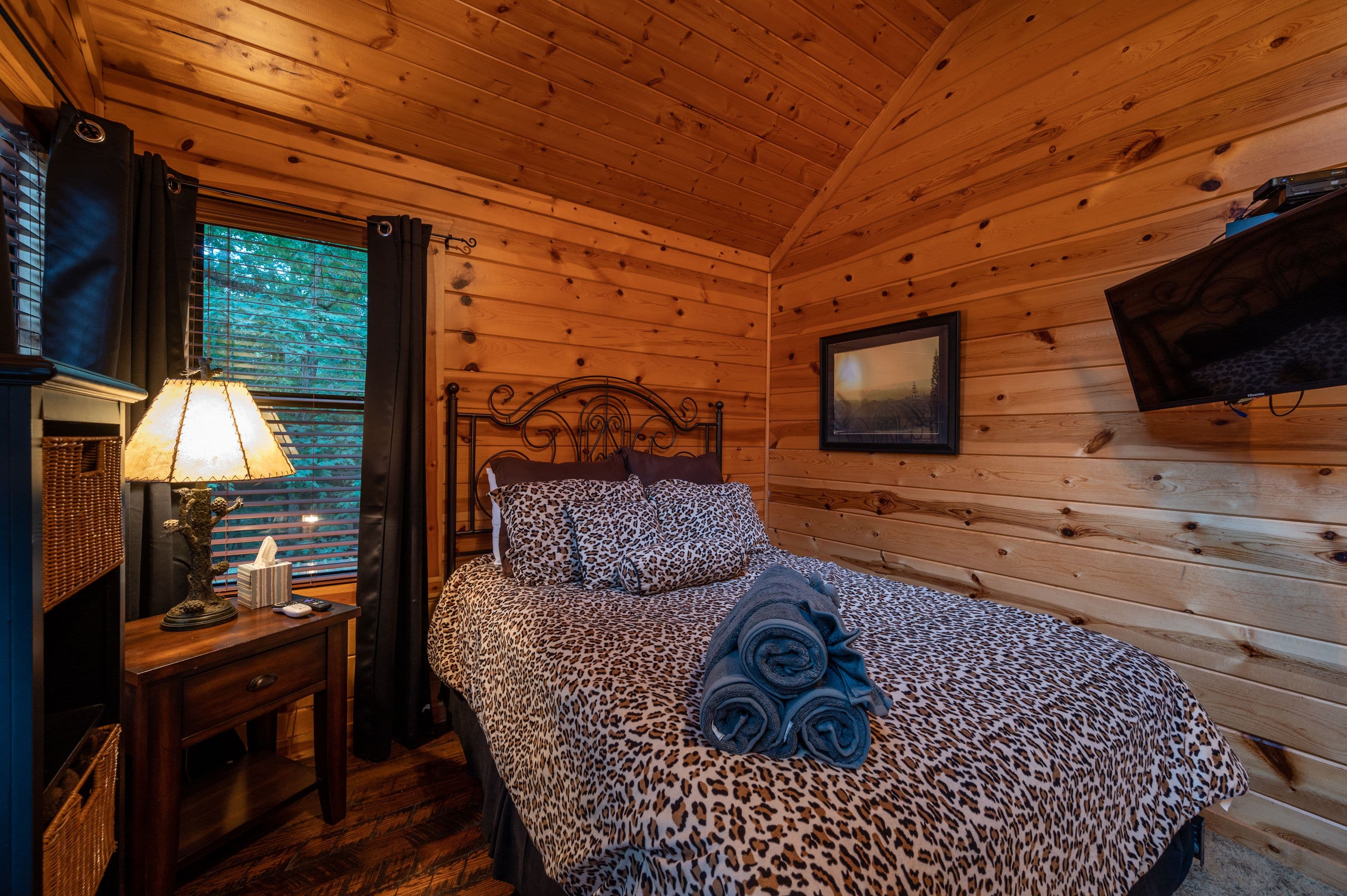 Upstairs bedroom with TV, side table, and lamp