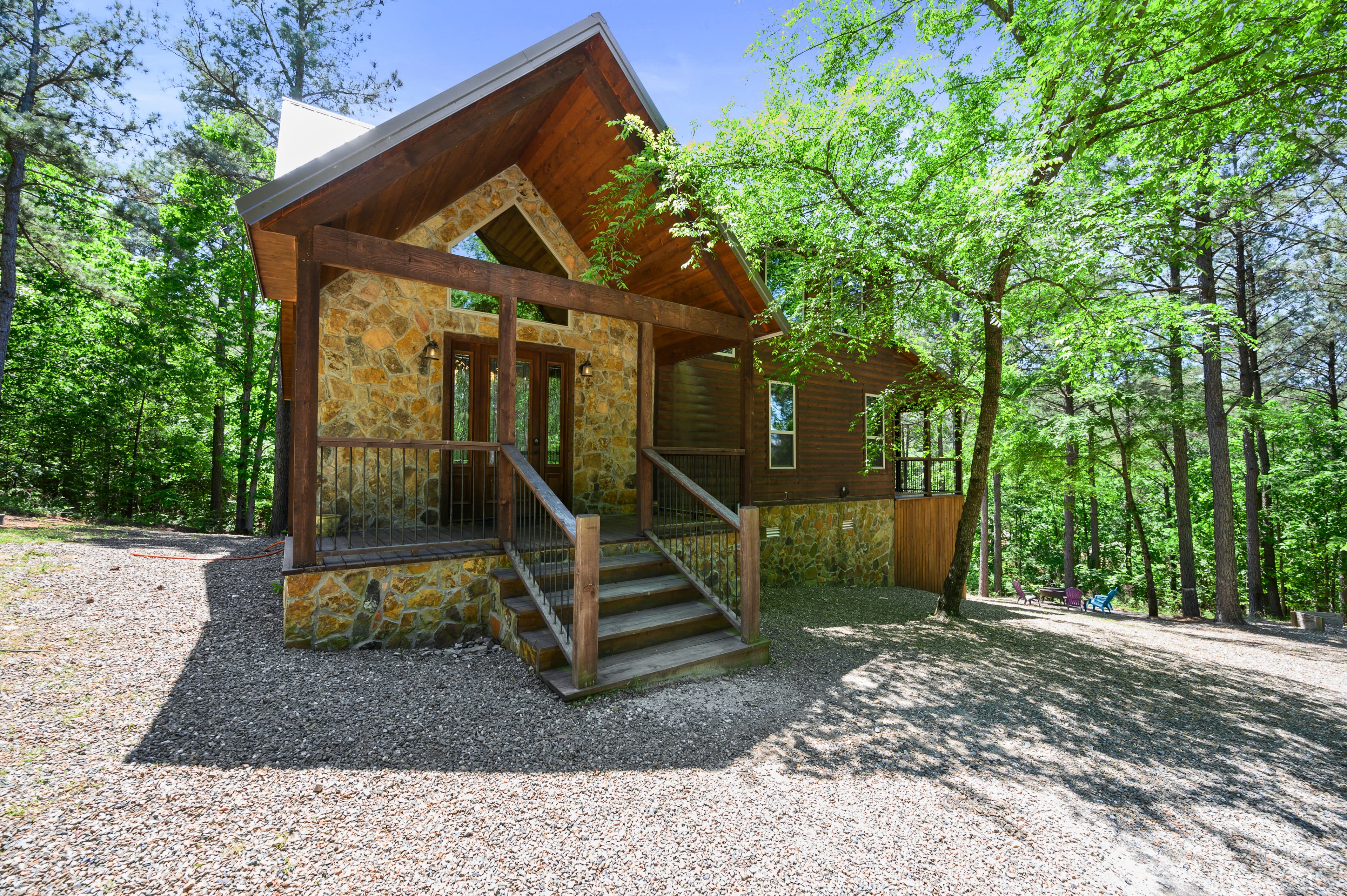 Front of log 2 story cabin with gravel driveway
