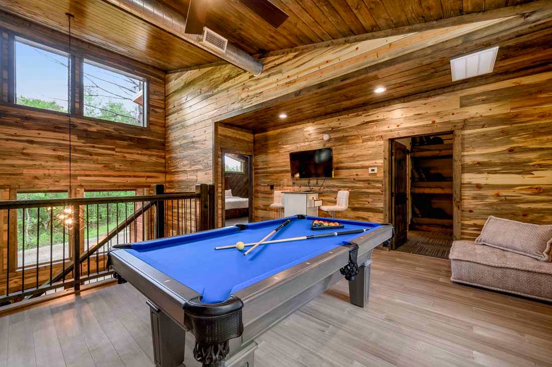 pool table, chair, tv, and arcade in upstairs open loft game room