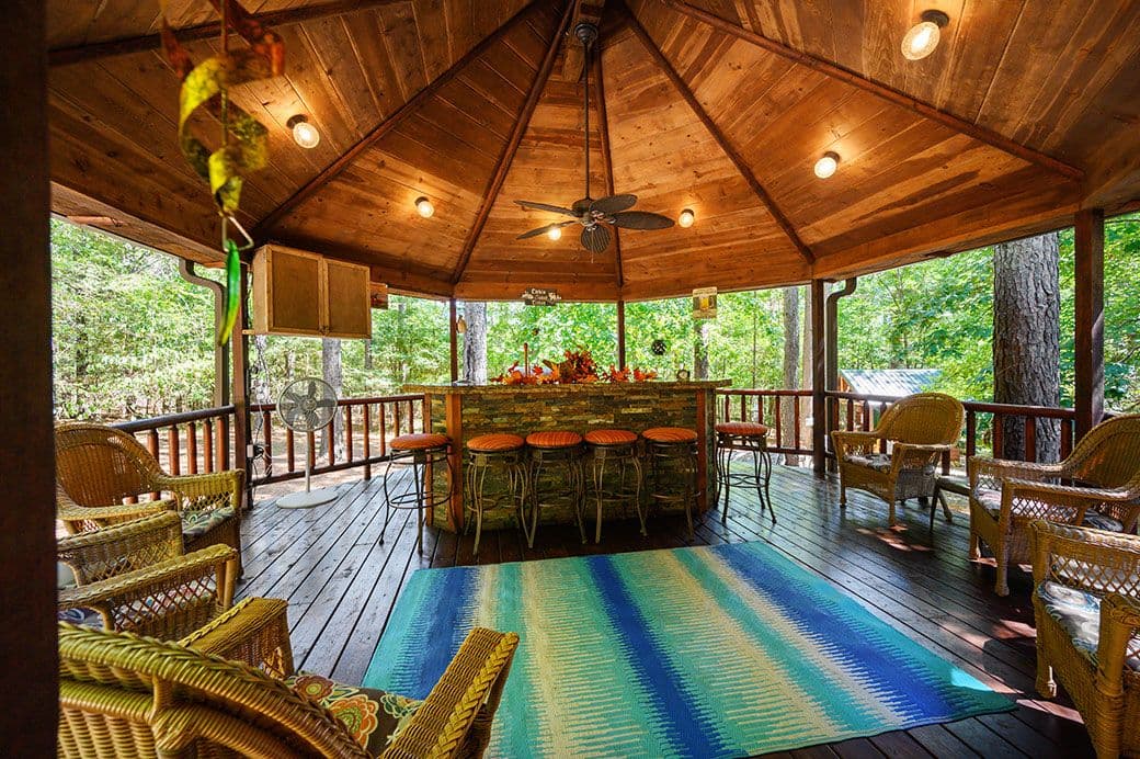Outdoor patio bar with bar stools and also chairs on the deck