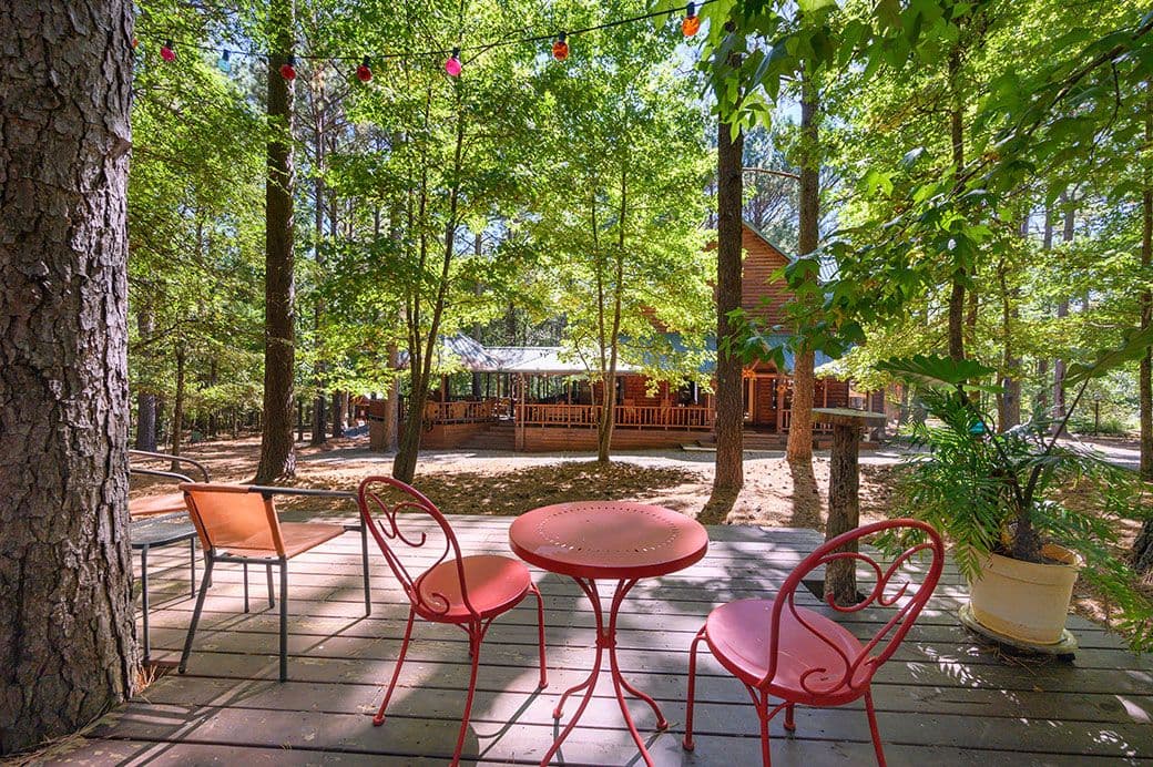 Extra wooden patio with a table, chairs, and colorful string lights