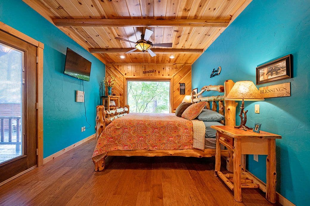 King bed in a large room, TV, side tables, & lamps