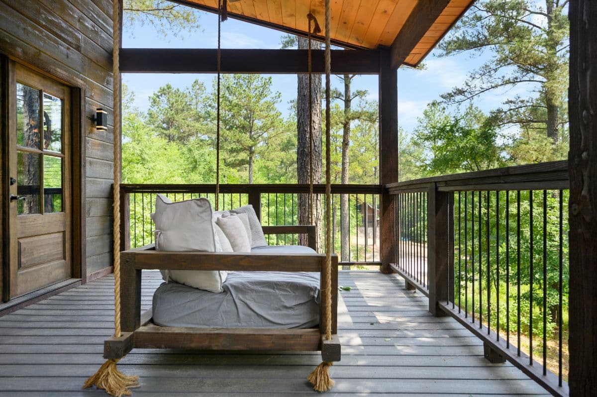 Swinging porch swing bench with cushions