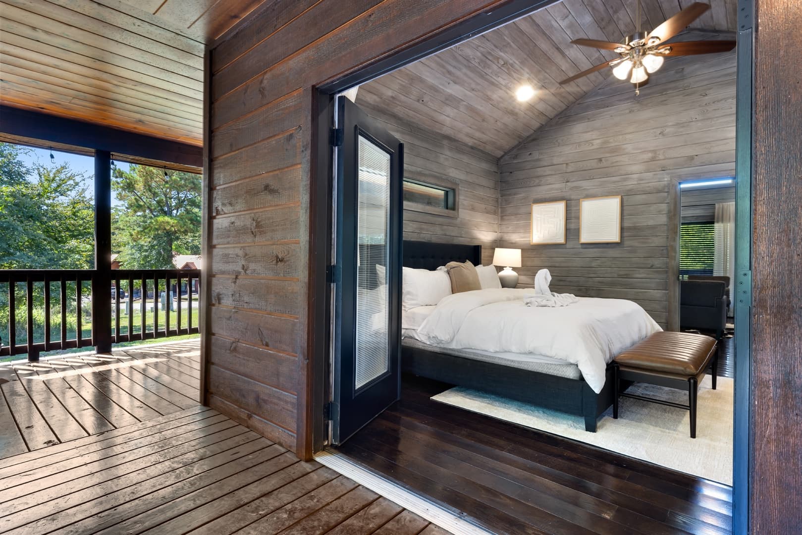 King bedroom with door opening up to wooden covered patio