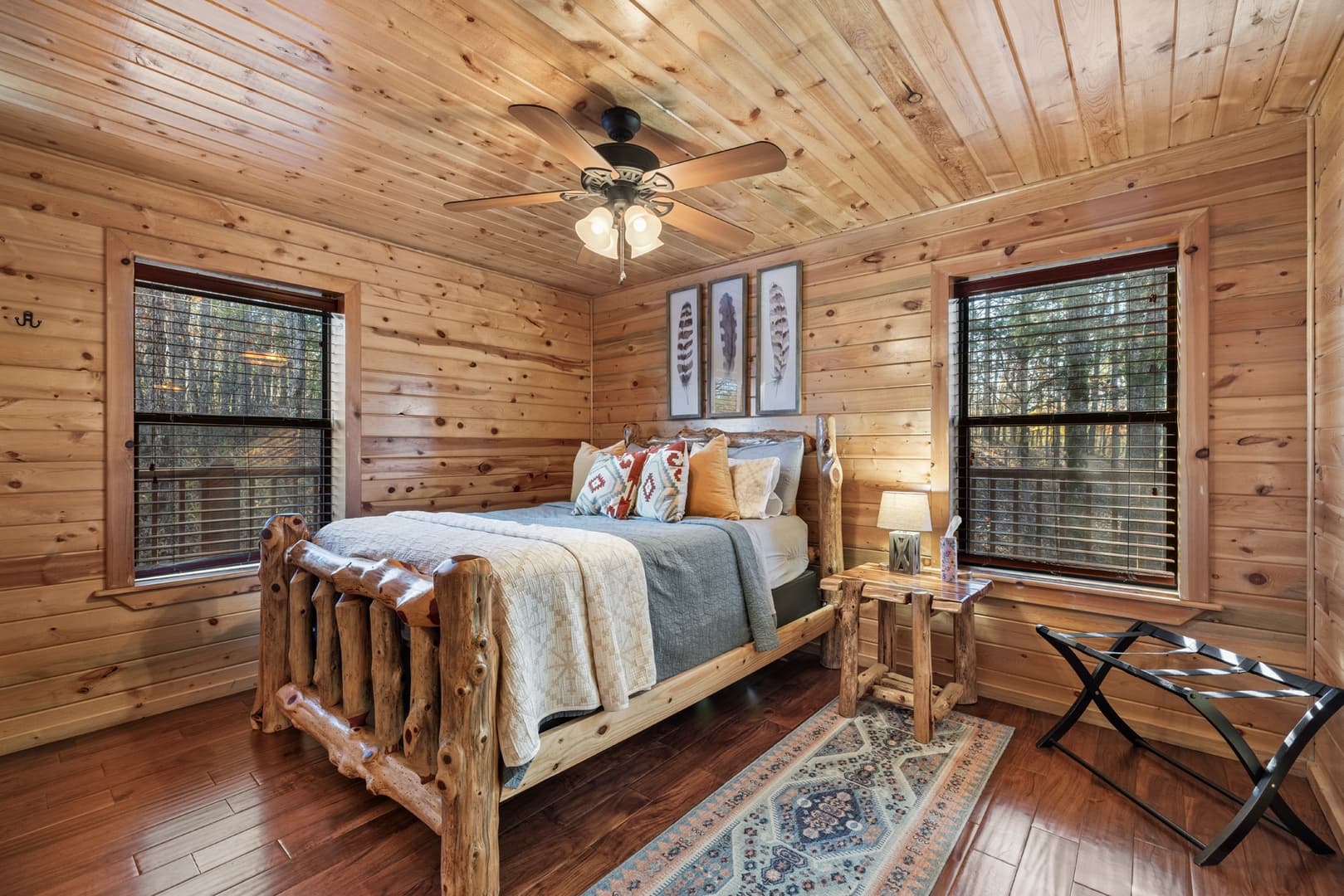 Bedroom with log bed, side table, lamp, and luggage rack