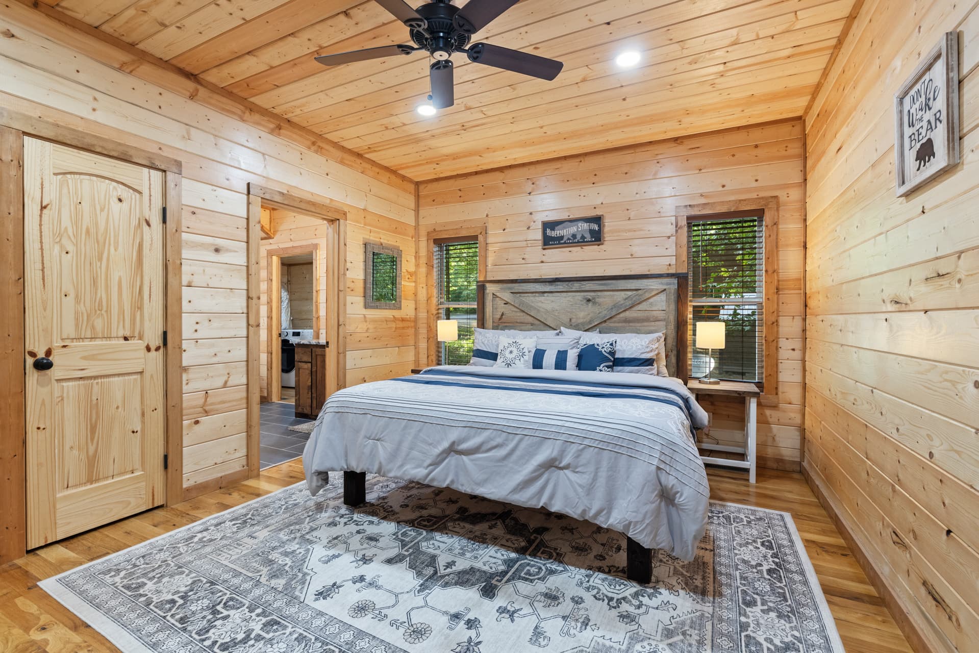 Cozy wooden cabin kitchen with stainless steel fridge and dining table set.