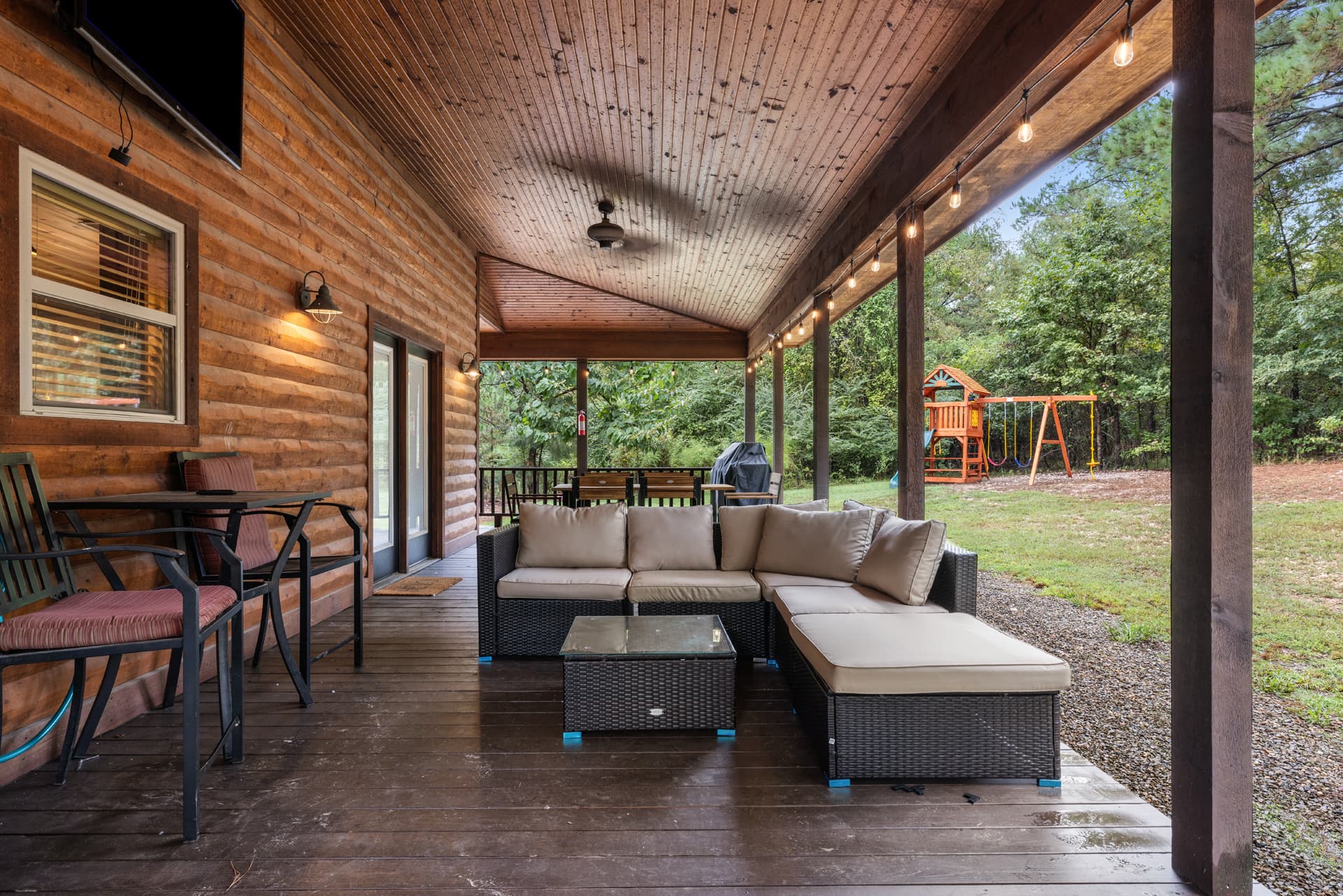 Hot tub under covered wooden patio and a table with chairs