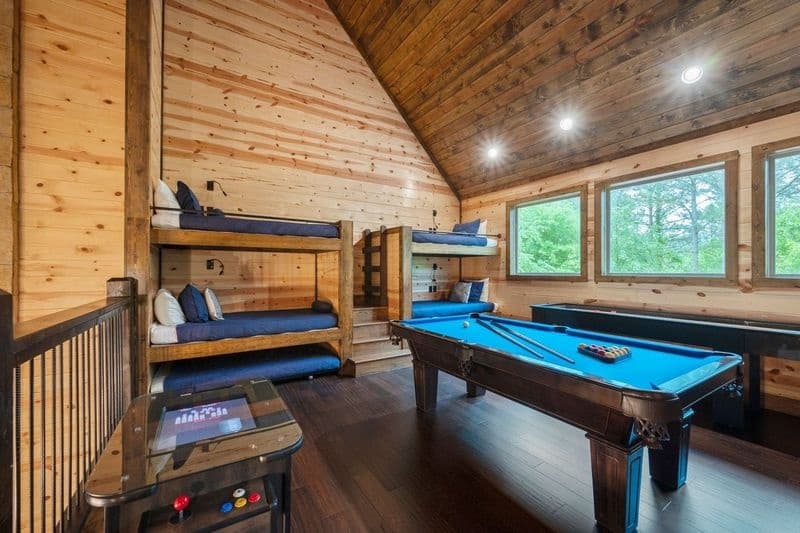 Game room loft with pool table, arcade, shuffleboard, and 2 sets of bunk beds
