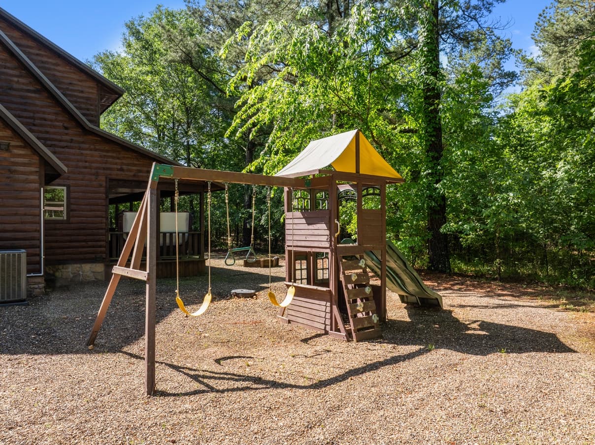 Playground with swings and slide in backyard