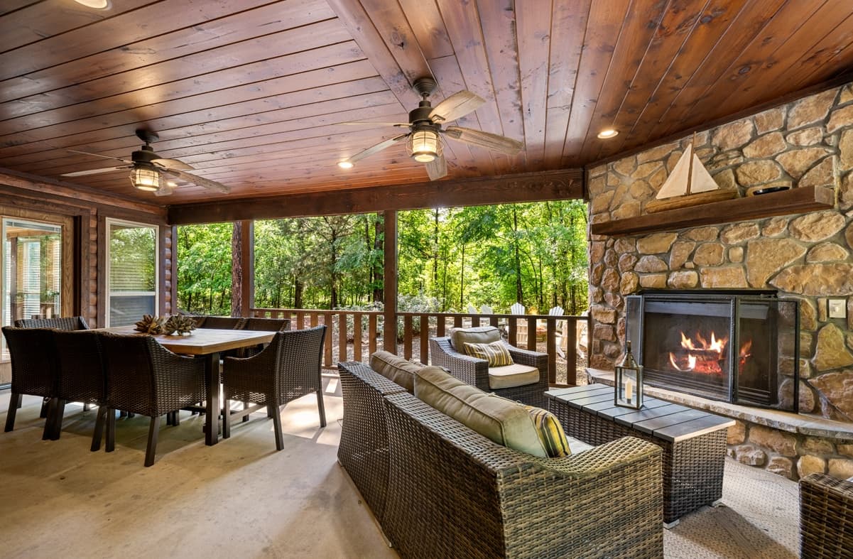 Outdoor patio with a table and fireplace, a couch, and loveseat