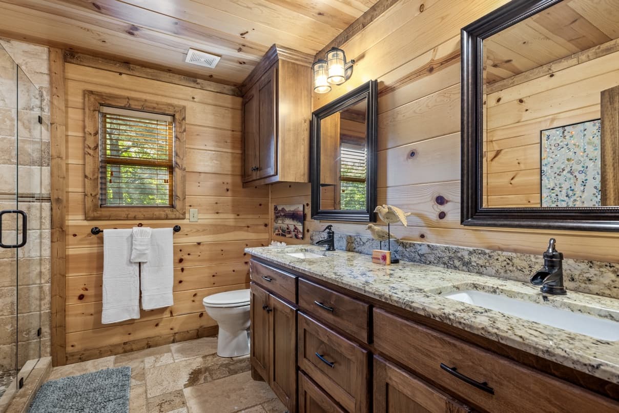 Bathroom sinks and tile shower with glass door