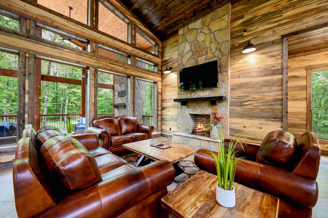 open living room with leather couches and a chair, fireplace, and TV
