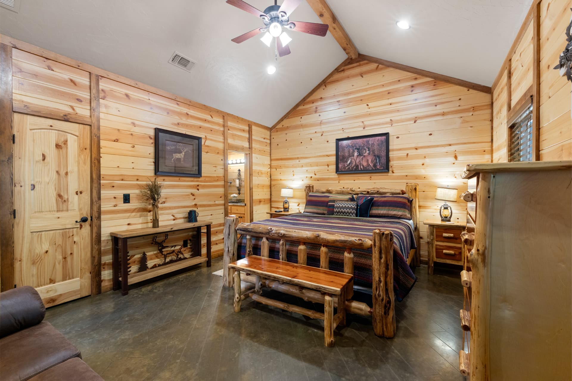 Cozy bedroom with log furniture and wooden wall paneling.