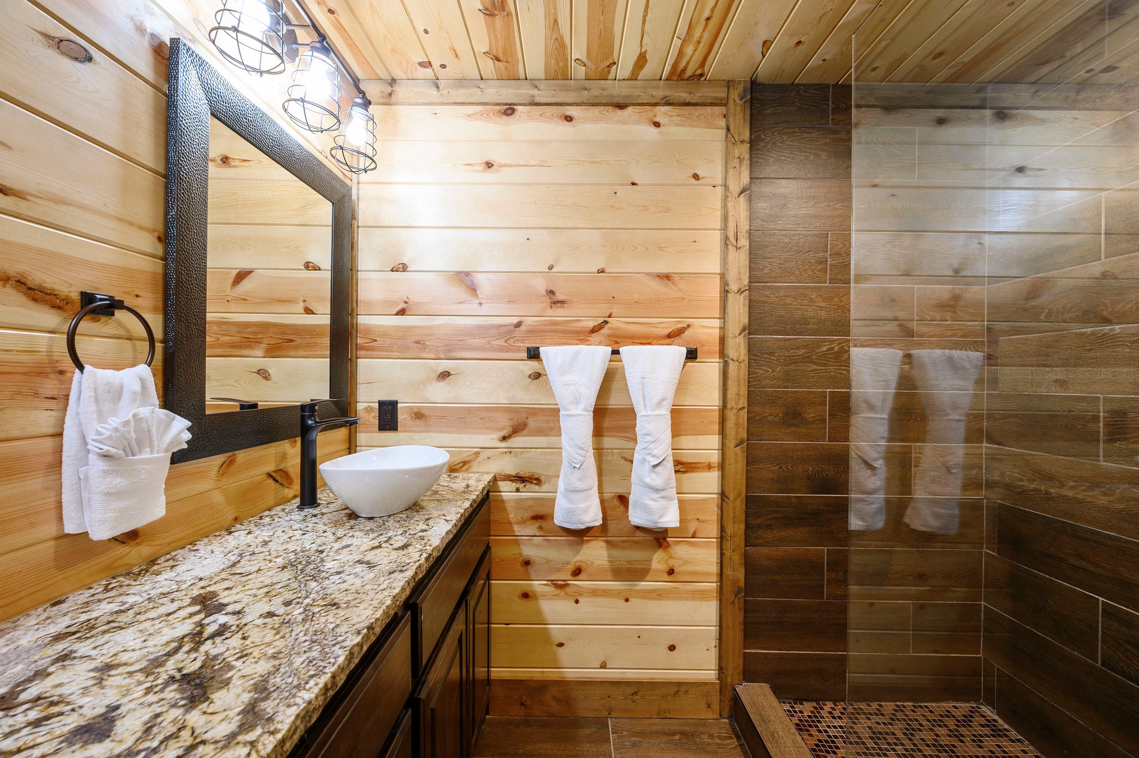 Bathroom with a rock floor shower and tile walls