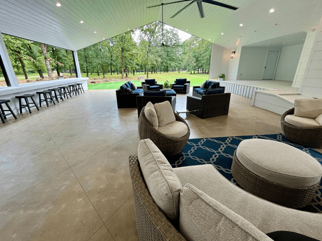 Spacious outdoor patio with comfortable seating and a scenic view of trees.