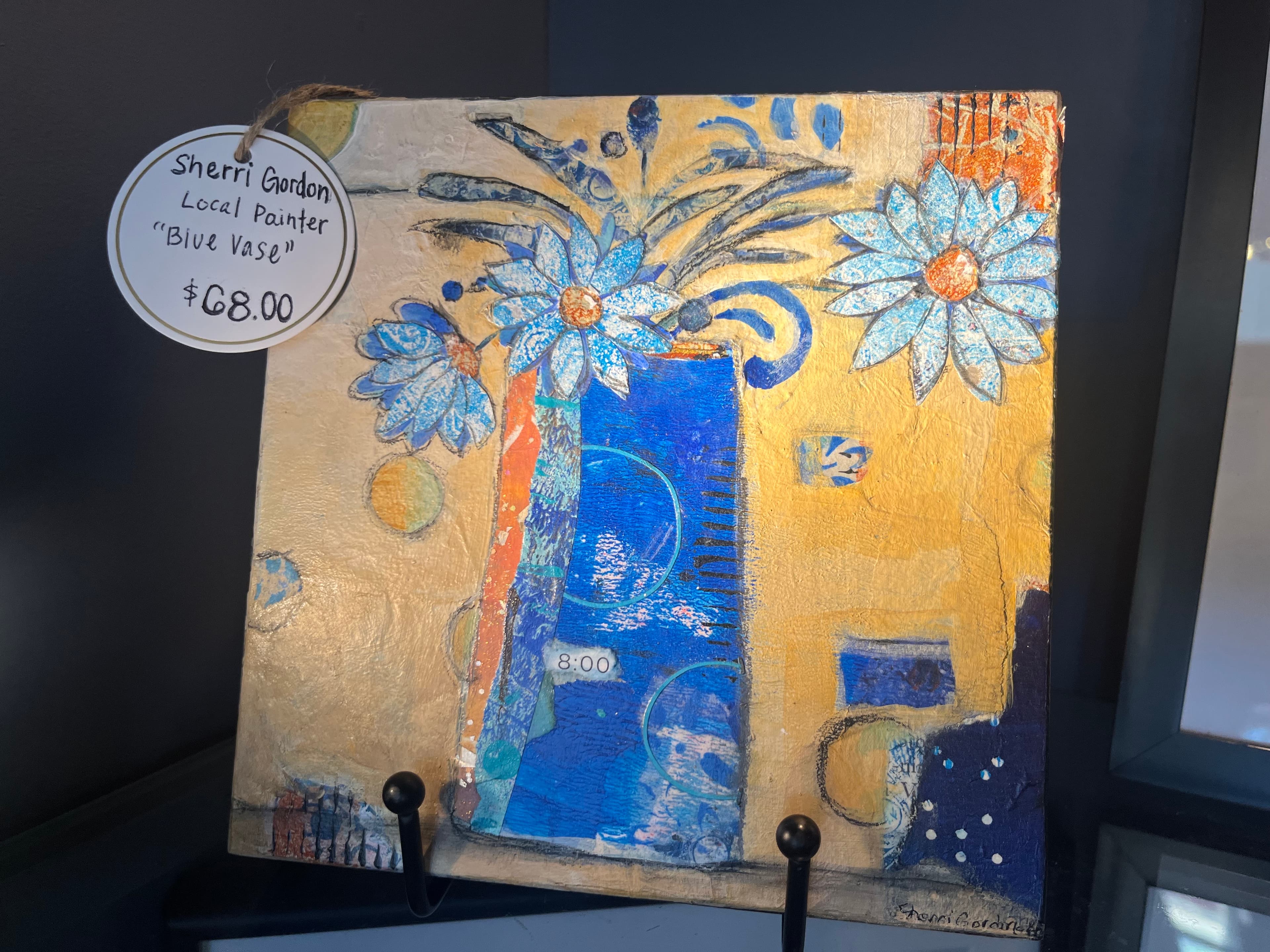 A colorful artwork featuring a blue vase and flowers, labeled "Blue Vase" by Sherri Gordon, priced at $68.00.
