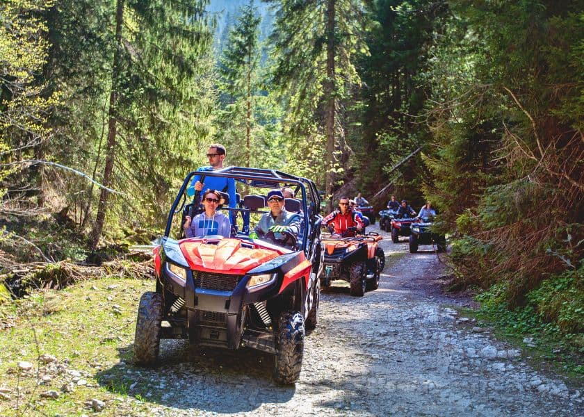 A group of people riding ATVs on a scenic forest trail. A group of people riding ATVs on a scenic forest trail.