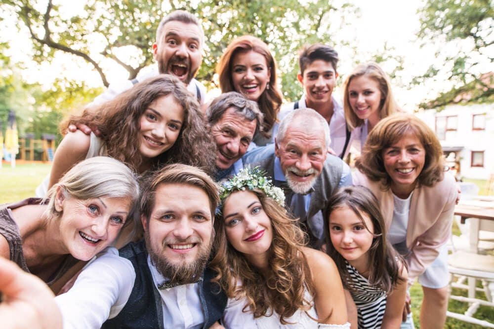 A joyful group of people posing for a selfie outdoors.