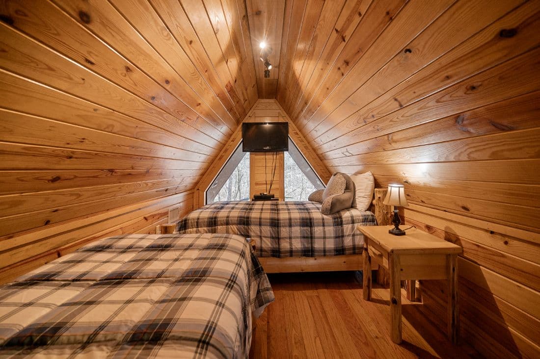 Bunk beds upstairs with TV, table, and lamp