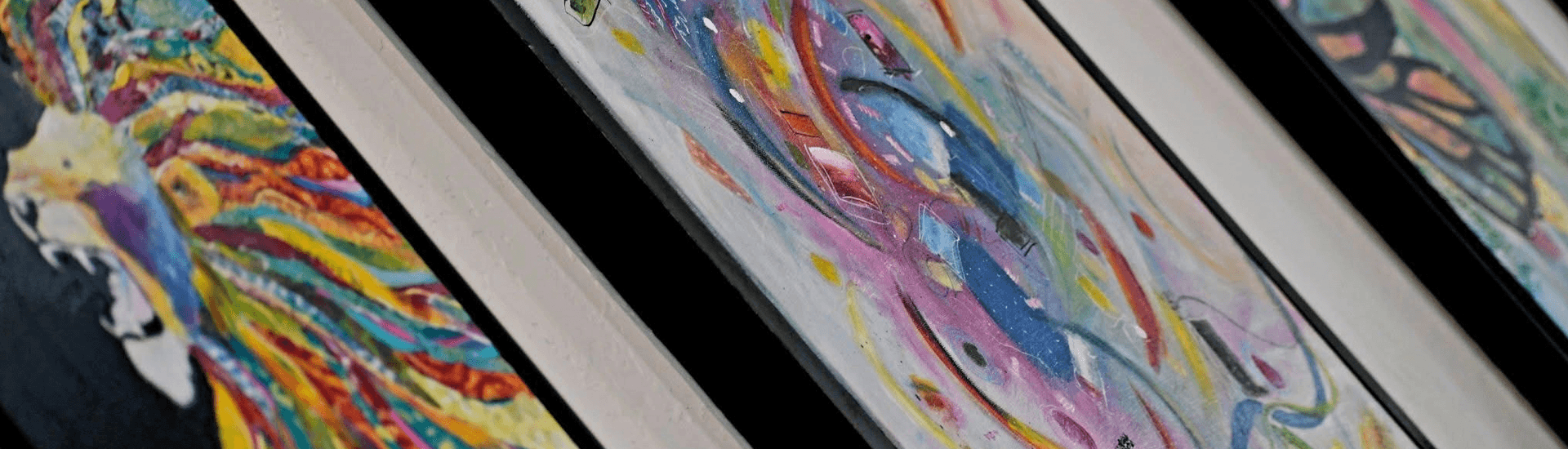 Colorful abstract paintings displayed at an angle.