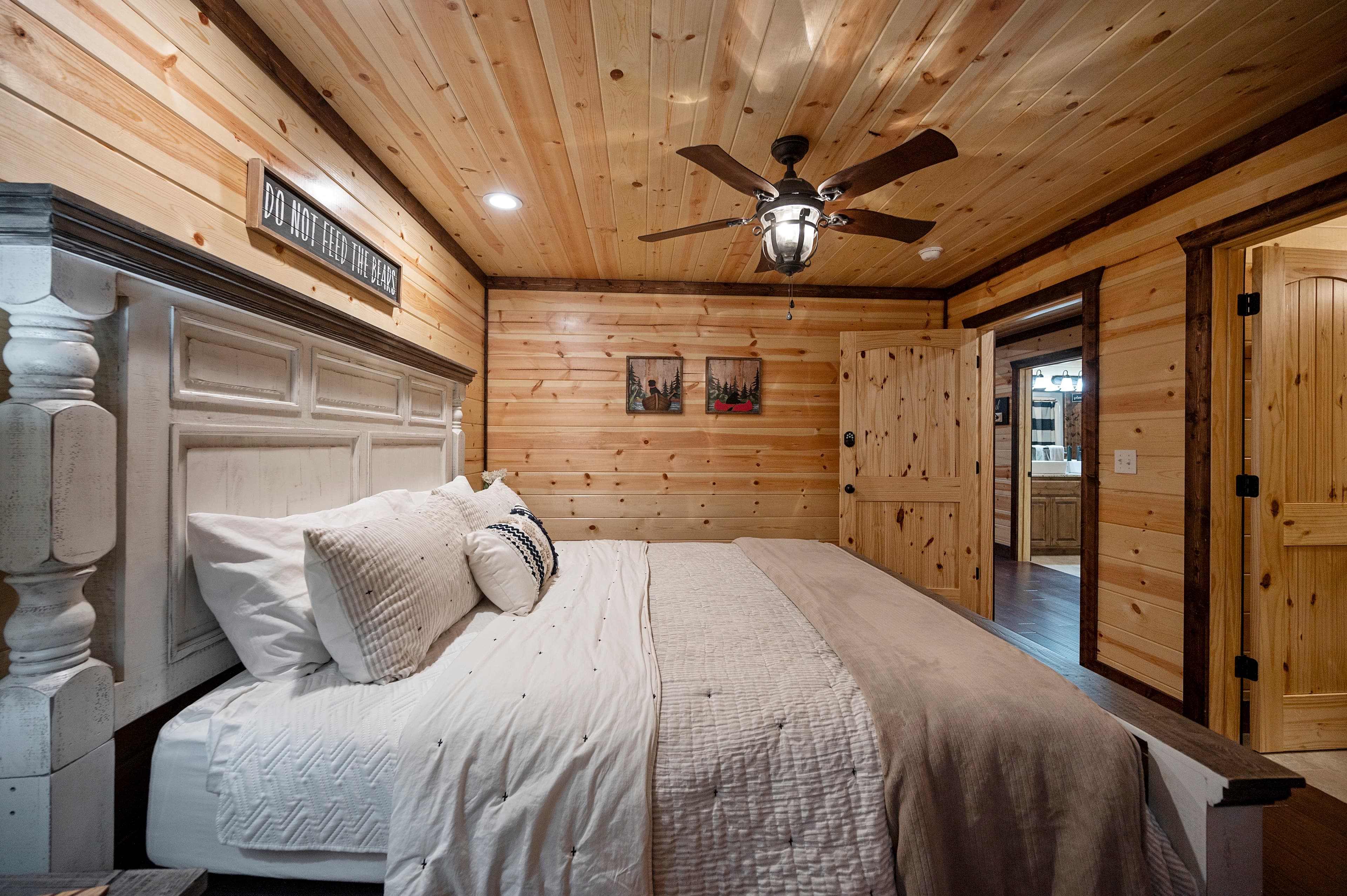 Cozy bedroom featuring a wooden ceiling, a vintage bed frame, and warm tones.
