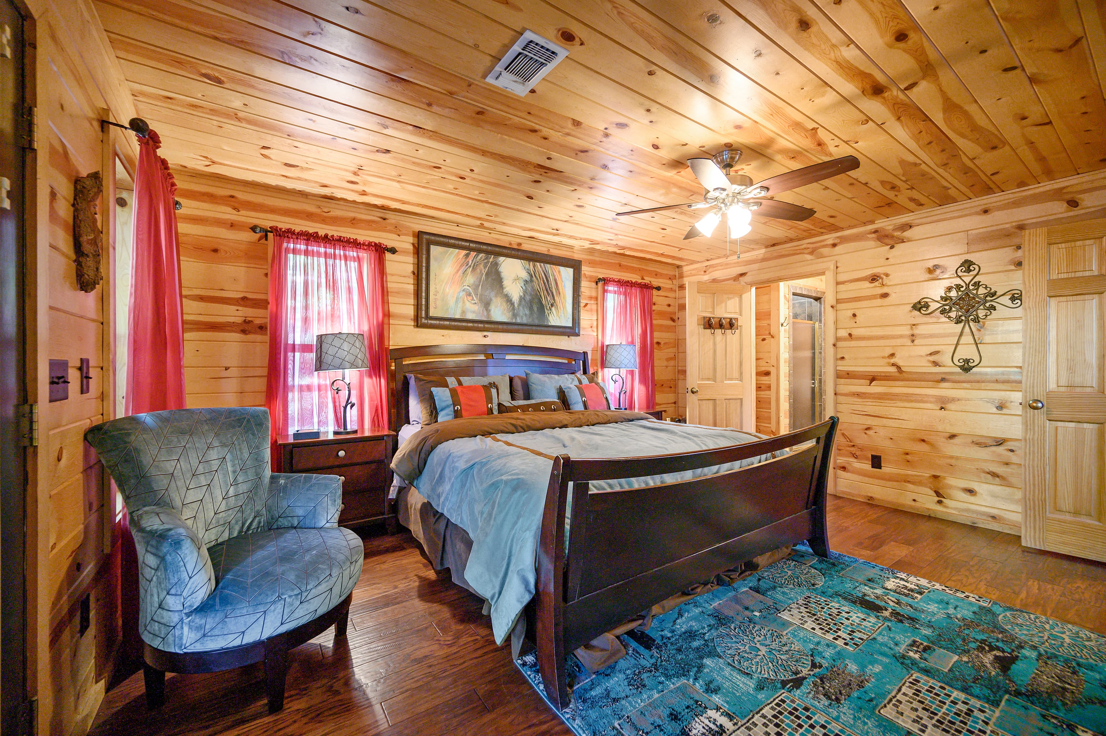 Downstairs king bedroom with chair, side tables, and TV