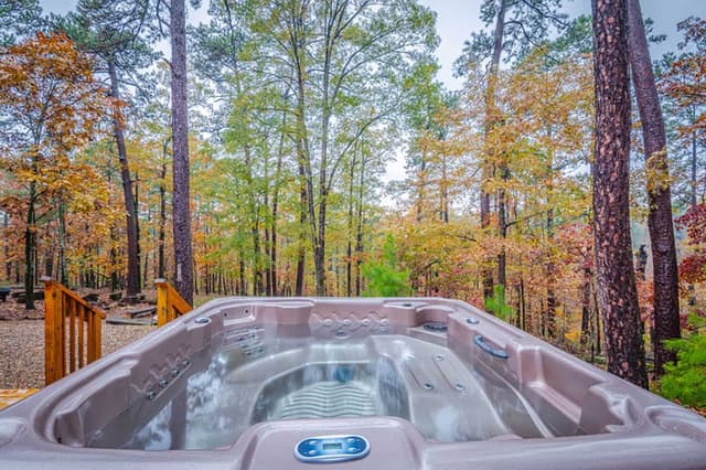 The hot tub of a Hochatown cabin rental overlooking Oklahoma fall foliage.